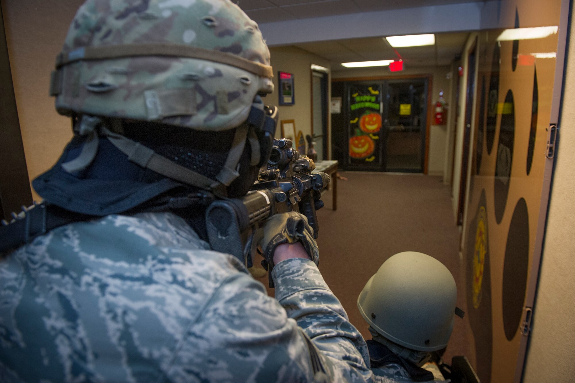 Members of the 49th Security Forces Squadron clear rooms while checking for hostiles during an active shooter exercise at Holloman Air Force Base, N.M., Oct. 9. Holloman exercises to maintain readiness in order to respond to emergencies such as active shooters. Members from the 49th Security Forces Squadron, 49th Civil Engineer Squadron and the 49th Medical Group were able to quickly respond to the exercise scenario, neutralize the threats and evacuate the victims. (U.S. Air Force photo by Airman 1st Class Aaron Montoya / Released)