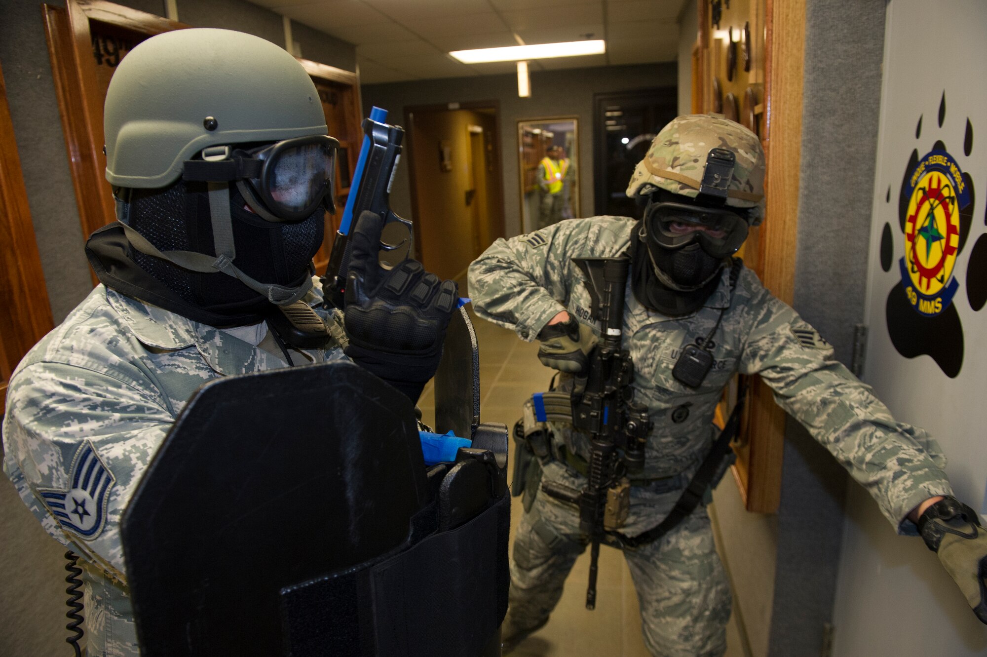 Members of the 49th Security Forces Squadron clear rooms while looking for hostiles during an active shooter exercise at Holloman Air Force Base, N.M., Oct. 9. Holloman exercises to maintain readiness in order to respond to emergencies such as active shooters. Members from the 49th Security Forces Squadron, 49th Civil Engineer Squadron and the 49th Medical Group were able to quickly respond to the exercise scenario, neutralize the threats and evacuate the victims. (U.S. Air Force photo by Airman 1st Class Aaron Montoya / Released)