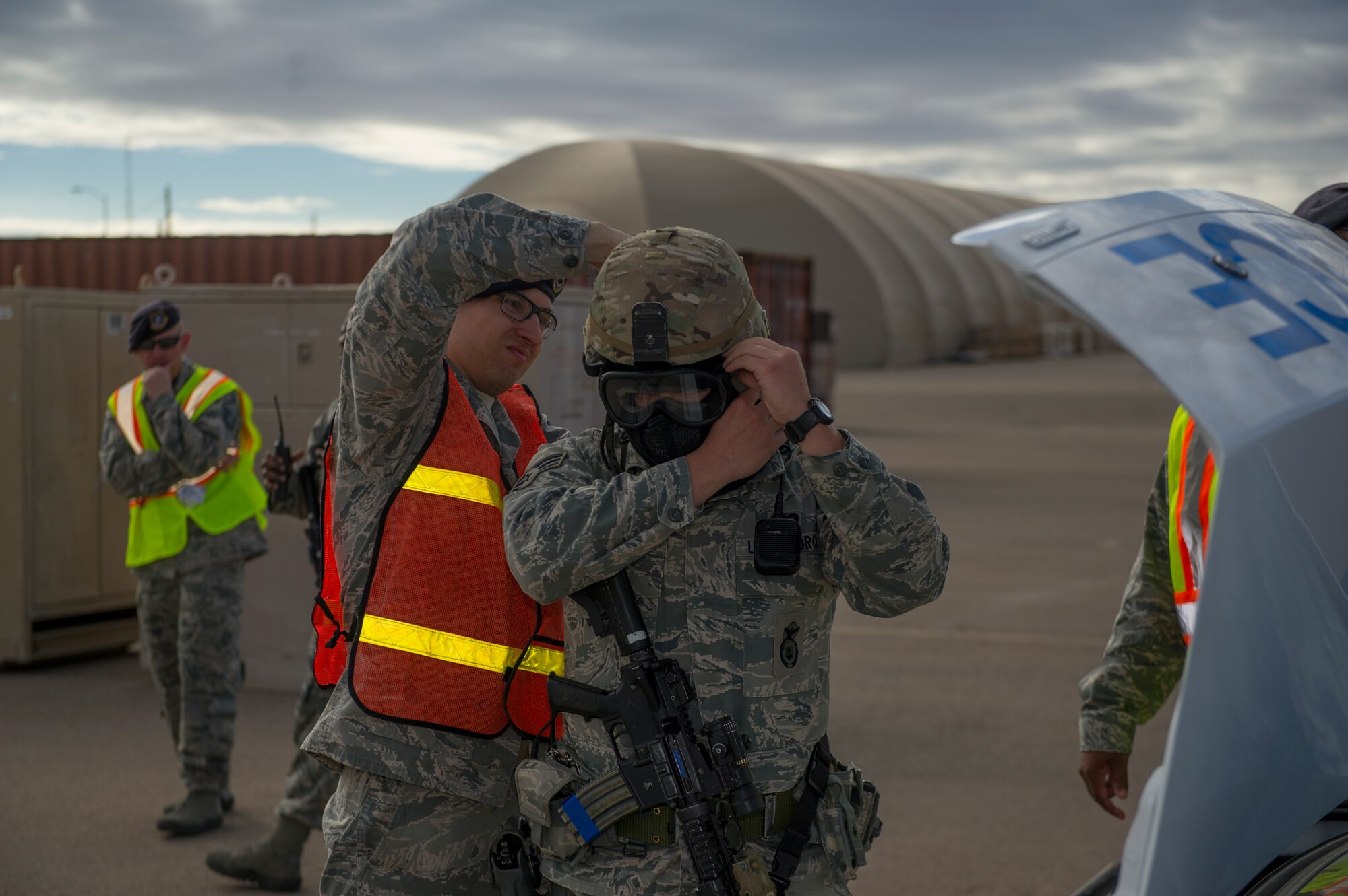 Members of the 49th Security Forces Squadron assist each other with applying their gear as they prepare to participate in an active shooter exercise at Holloman Air Force Base, N.M., Oct. 9. Holloman maintains readiness to respond to emergencies such as active shooters by conducting training exercises multiple times a year. Members from the 49th Security Forces Squadron, 49th Civil Engineer Squadron and the 49th Medical Group were able to quickly respond to the exercise scenario, neutralize the threats and evacuate the victims. (U.S. Air Force photo by Airman 1st Class Aaron Montoya / Released)