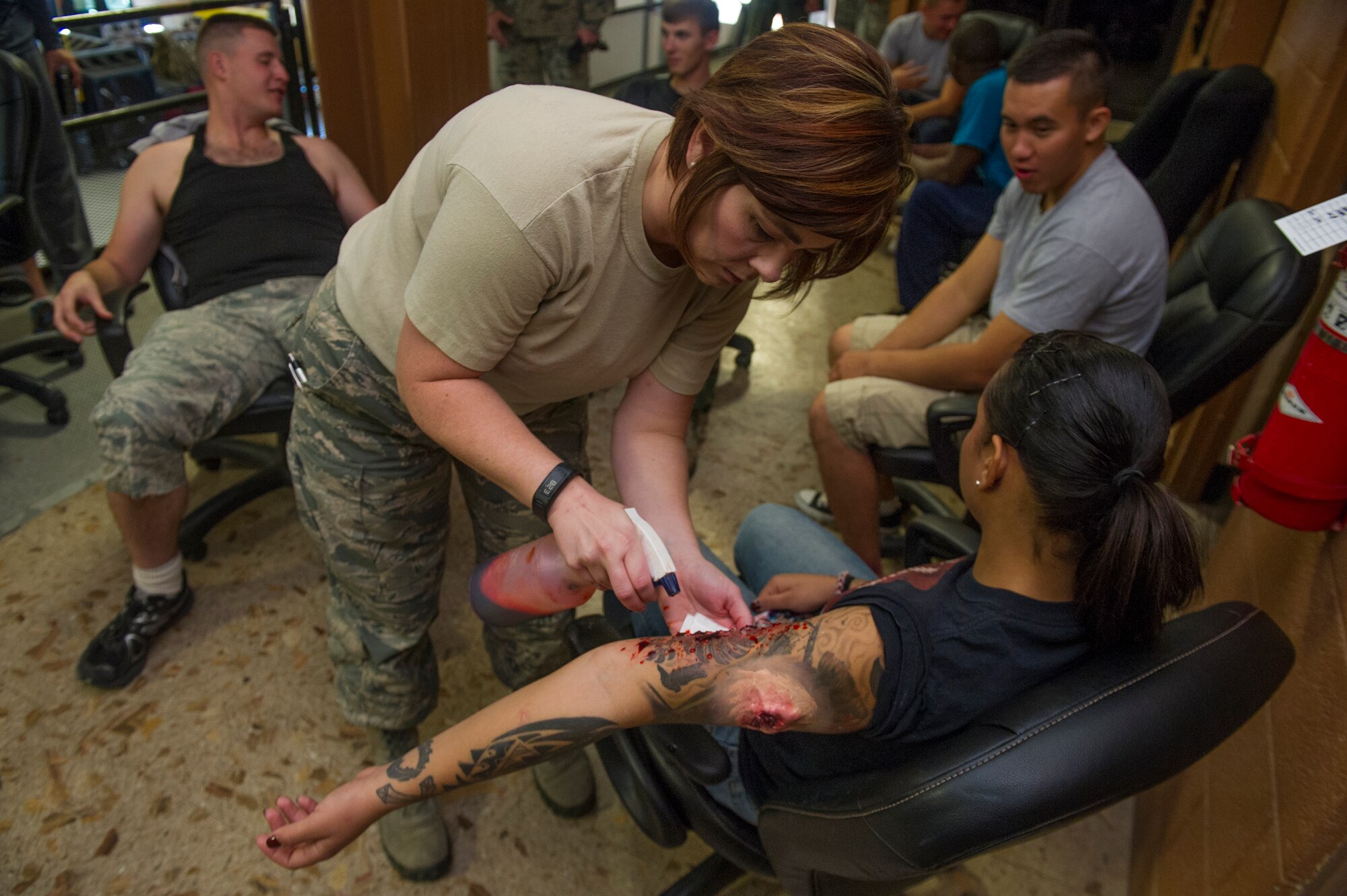 A member of the 49th Medical Group applies a simulated bullet wound to a victim participant during an active shooter exercise at Holloman Air Force Base, N.M., Oct. 9 Holloman exercises to maintain readiness in order to respond to emergencies such as active shooters. Members from the 49th Security Forces Squadron, 49th Civil Engineer Squadron and the 49th Medical Group were able to quickly respond to the exercise scenario, neutralize the threats and evacuate the victims. (U.S. Air Force photo by Airman 1st Class Aaron Montoya / Released)