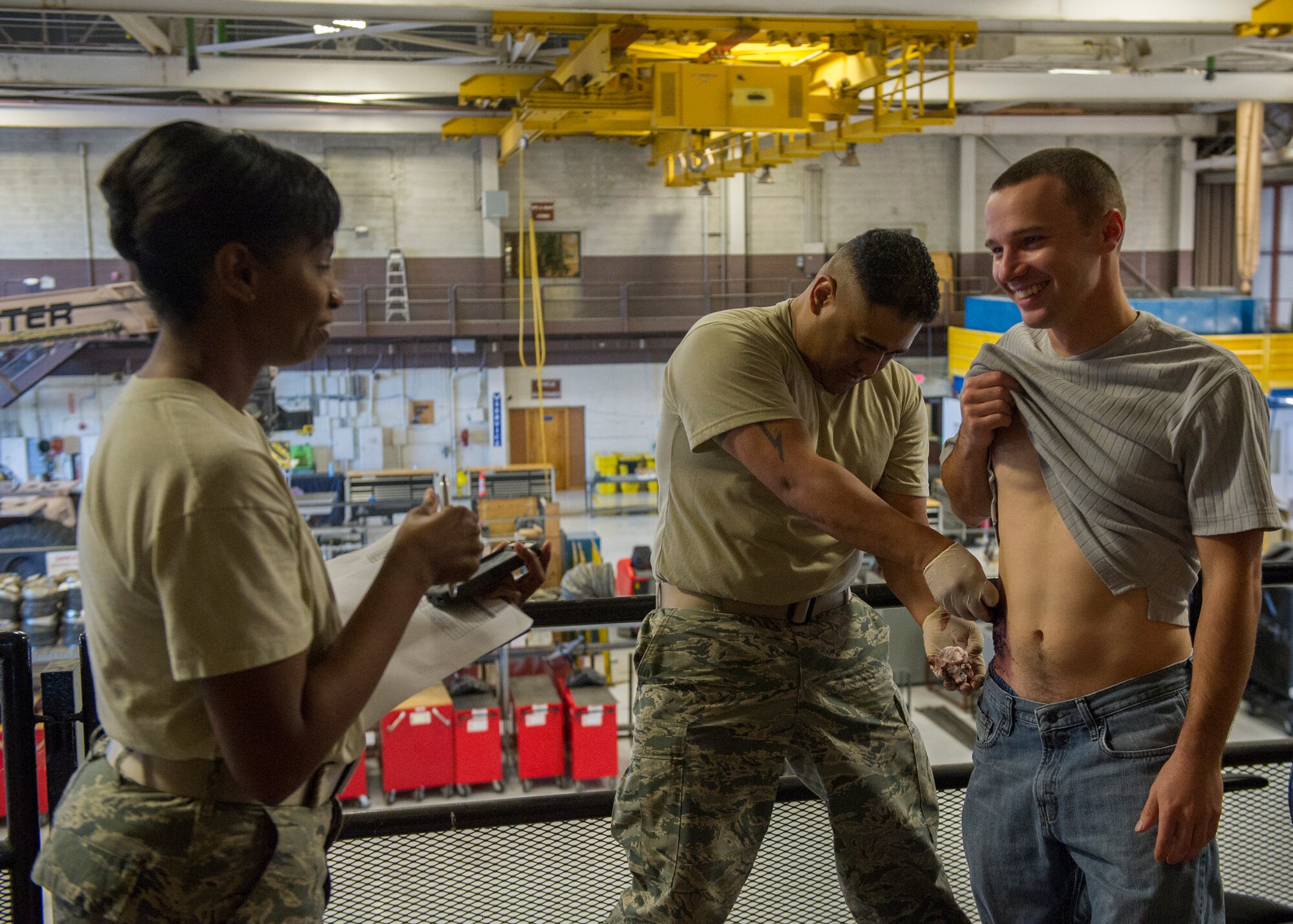 Members of the 49th Medical Group apply a simulated bullet wound to a victim participant during an active shooter exercise at Holloman Air Force Base, N.M., Oct. 9. Holloman exercises to maintain readiness in order to respond to emergencies such as active shooters. Members from the 49th Security Forces Squadron, 49th Civil Engineer Squadron and the 49th Medical Group were able to quickly respond to the exercise scenario, neutralize the threats and evacuate the victims. (U.S. Air Force photo by Airman 1st Class Aaron Montoya / Released)