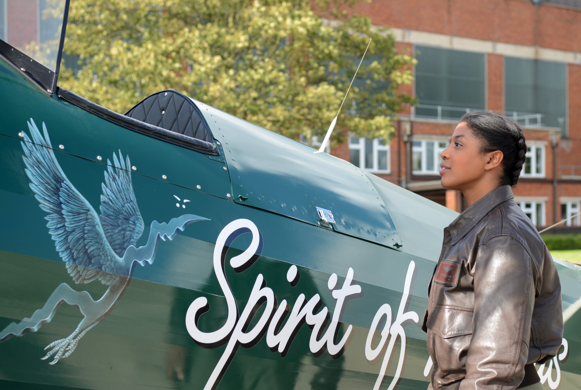 U.S. Air Force Maj. Tai Moultrie-Korn, 100th Operations Group strategy and plans coordinator from Colleyville, Texas, admires a Boeing Stearman biplane Oct. 10, 2014, on RAF Mildenhall, England. The biplane carried Tracey Curtis-Taylor, an aviation enthusiast from Goodwood, England, on her 10,000 mile journey across Africa in 2013. (U.S. Air Force photo/Airman 1st Class Kyla Gifford/Released)