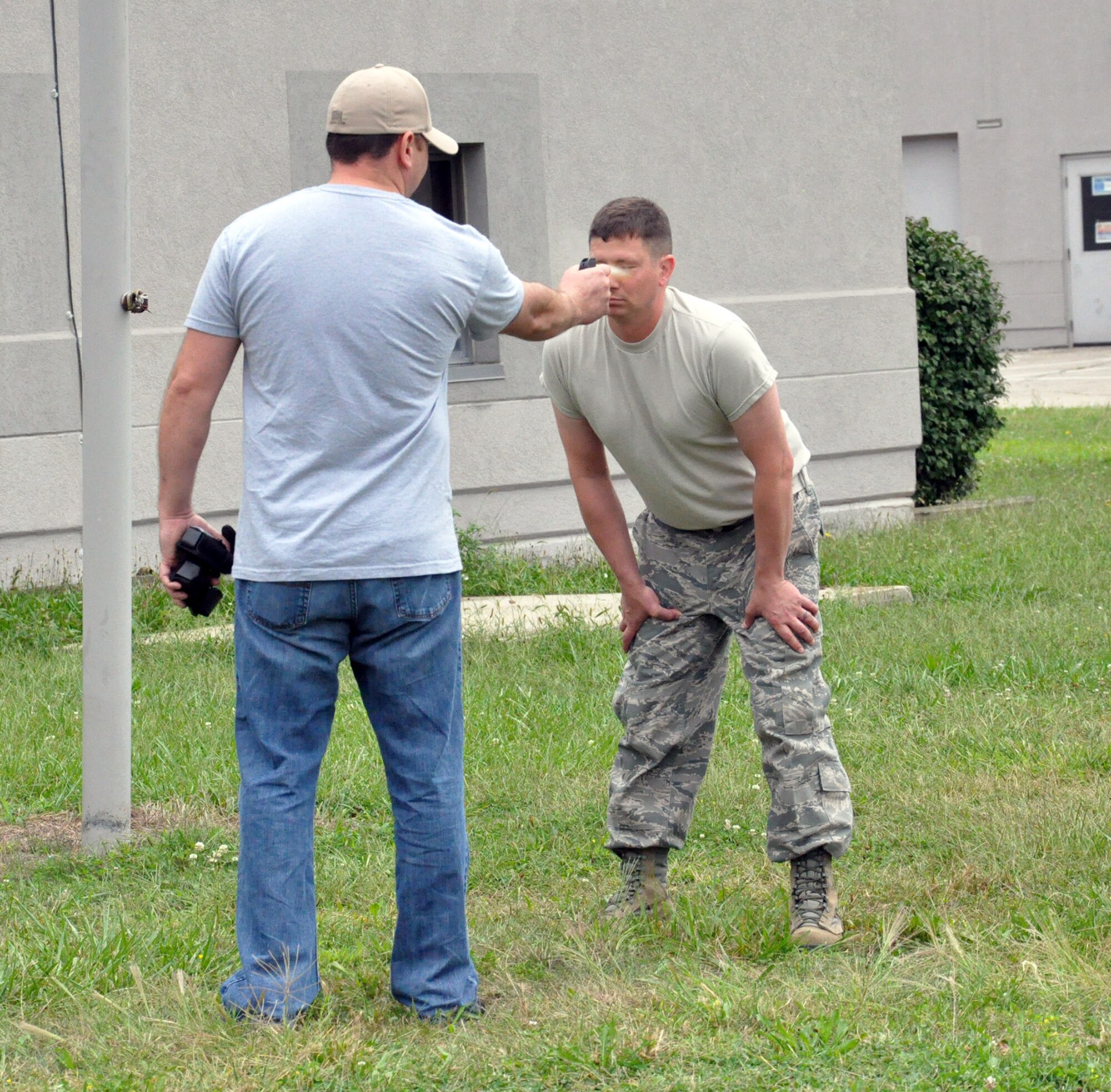 WRIGHT-PATTERSON AIR FORCE BASE, Ohio - 445th Security Forces Squadron reservists Staff Sgt. Jared Applegate sprays Staff Sgt. Lawrence Heninger in the face with Oleoresin Capsicum (OC) pepper spray before Heninger completes various law enforcement scenarios Sept 6, 2014. All members of the 445 SFS must experience the OC pepper spray once as part of annual less-than-lethal force training. (U.S. Air Force photo/Capt. Elizabeth Caraway)