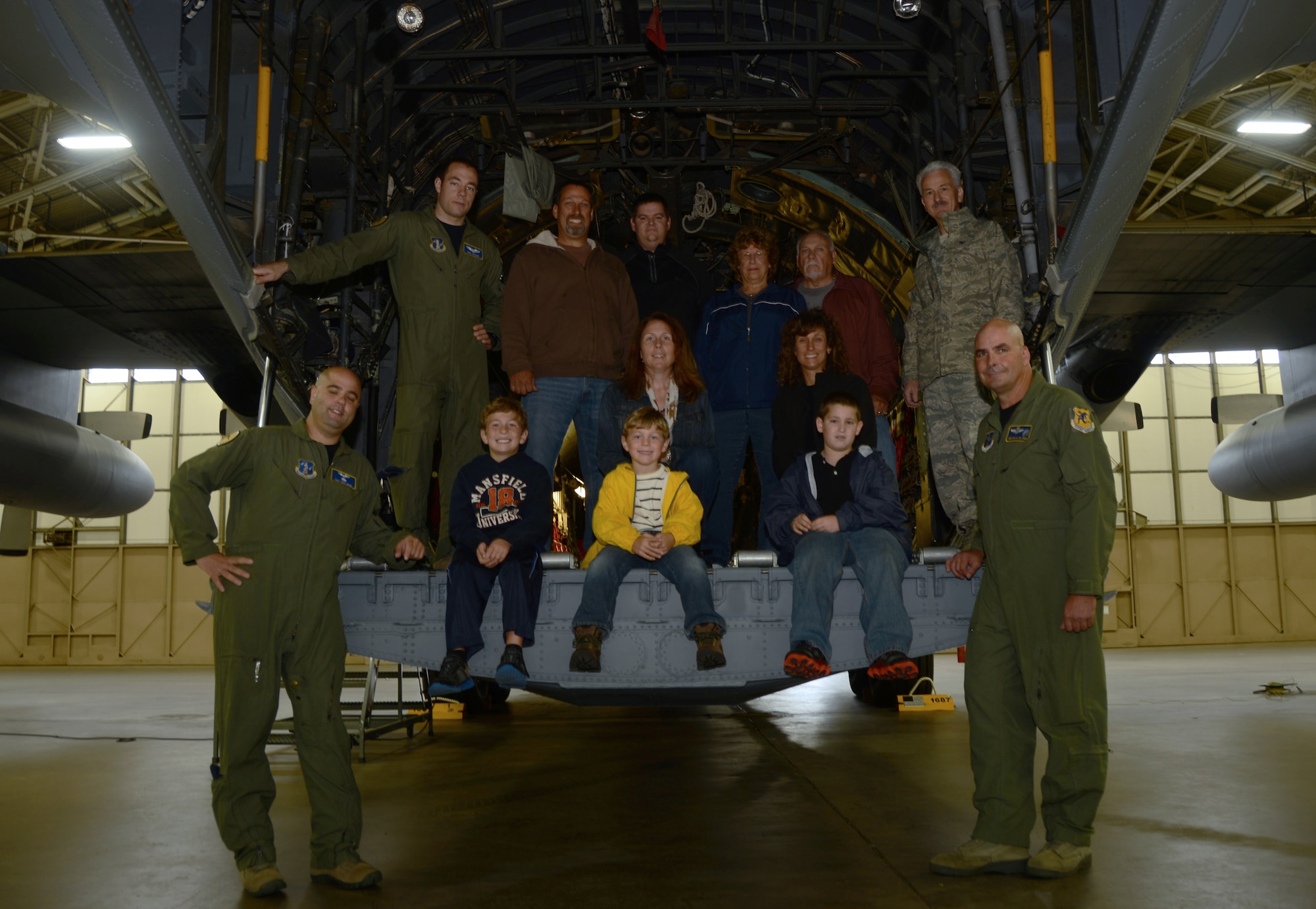 Employees of Fillmore Express Inc. and their families pose with their 103rd Airlift Wing tour guides (bottom left, Tech. Sgt. Tufic Paone; bottom right, Master Sgt. Bryan Watson; top left, 1st Lt. Alan Bolduc; and top right, Col. Frederick Miclon) after completing their tour of a C-130H Hercules aircraft at Bradley Air National Guard Base, East Granby, Conn., Oct. 4, 2014. Employees of Fillmore and their families were invited on a base tour to thank them for the signs they posted outside of their business supporting the Airmen of Bradley Air National Guard Base. (Air National Guard photo by Senior Airman Jennifer Pierce)