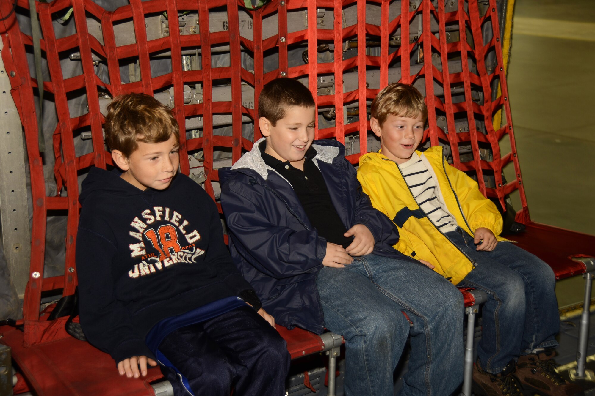 (From left to right) Colton Fillmore, 8, Nathan Defreitas, 8, and Landon Fillmore, 6, take a seat during their tour in a C-130H Herculees aircraft at Bradley Air National Guard Base, East Granby, Conn., Oct. 4, 2014. The boys are family members of employees of Fillmore Express Inc. who took part in a base tour. (Air National Guard photo by Senior Airman Jennifer Pierce)