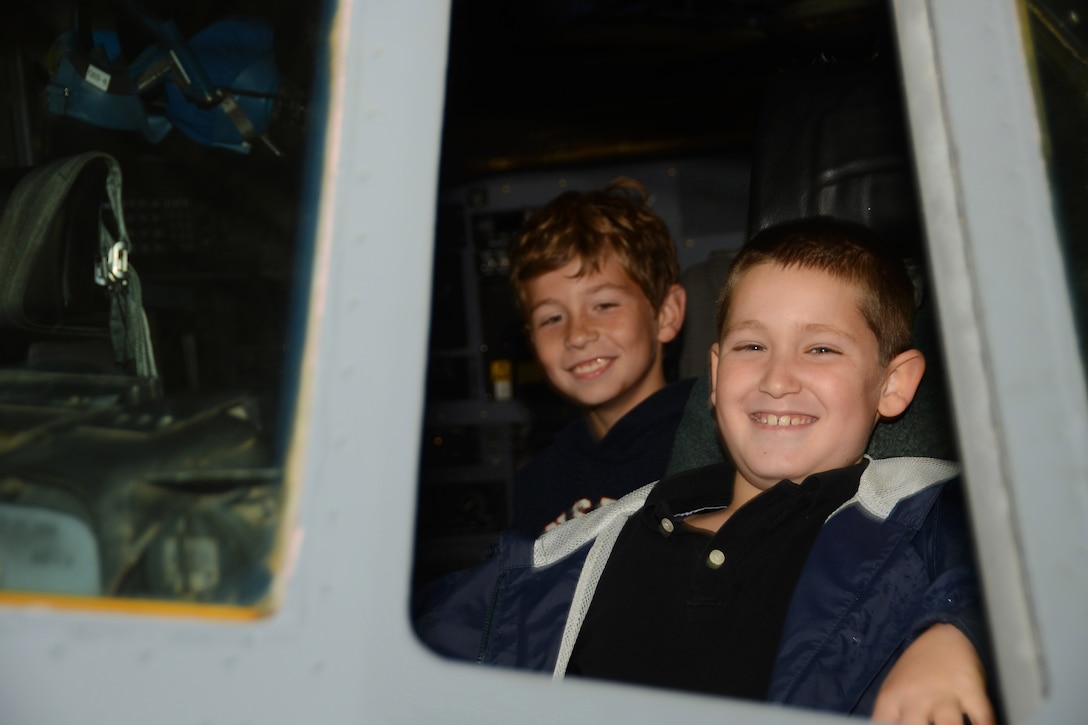 Nathan Defreitas, 8, sits in the cockpit of a C-130H Hercules aircraft with Colton Fillmore, 8, looking on behind him at Bradley Air National Guard Base, East Granby, Conn., Oct. 4, 2014. Defreitas and Fillmore both  participated in a base tour given to employees of Fillmore Express Inc. (Air National Guard photo by Senior Airman Jennifer Pierce)