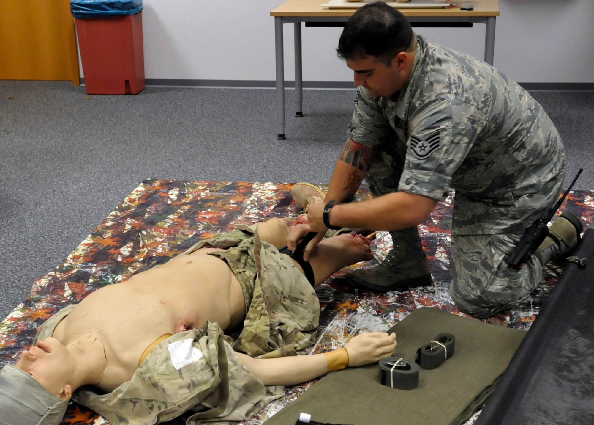 Staff Sgt. Antonio Sixto, 86th Medical Operations Squadron NCO in charge of emergency responses, demonstrates how to apply a combat application tourniquet during a self-aid and buddy care hands-on class at Ramstein Air Base, Germany, Oct. 7, 2014. SABC is intended to provide basic first-aid training to preserve life, limb and eyesight. It is generally divided into two categories: care under fire and tactical field care. (U.S. Air Force photo/Senior Airman Timothy Moore)