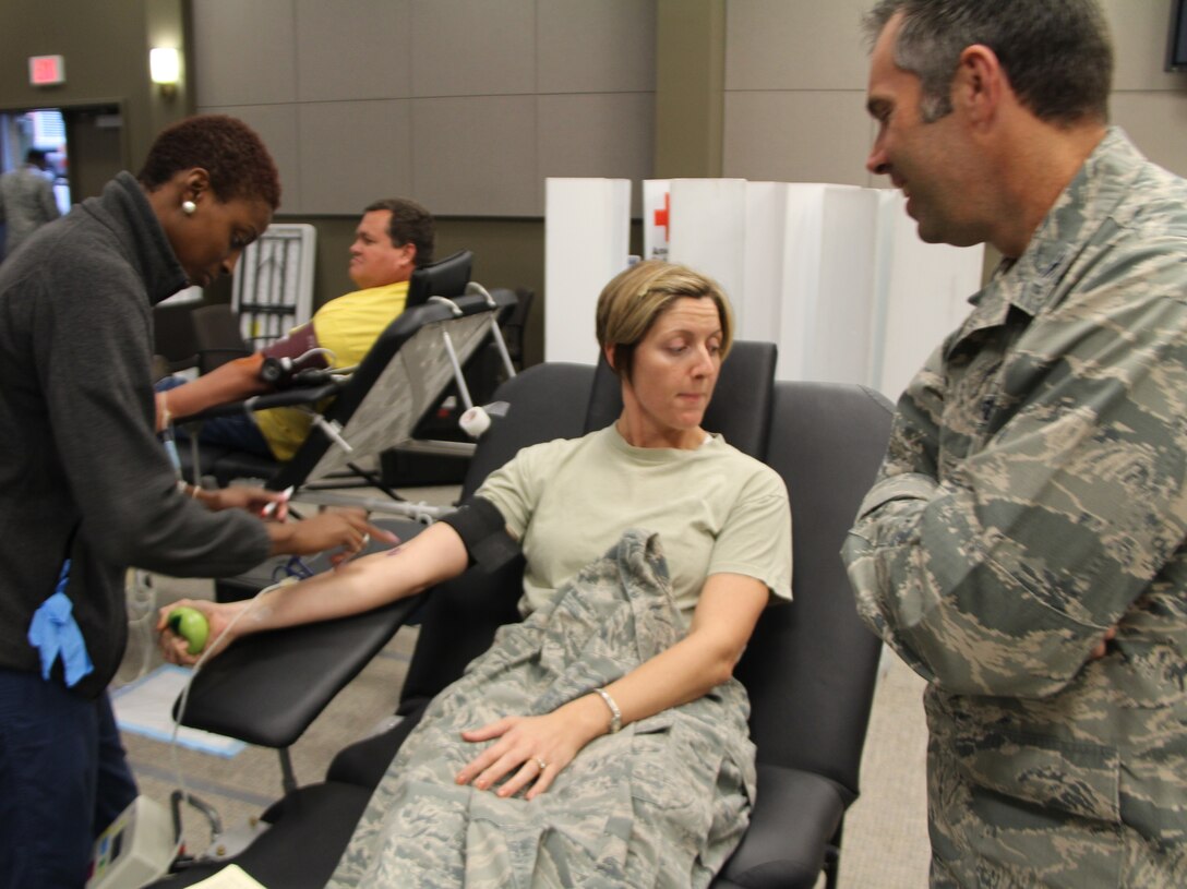 A Red Cross worker prepares the arm of First Lieutenant Elizabeth Wszalek for a blood donation while the 932nd Airlift Wing commander, Col. Karl Goerke, offers encouragement to his executive officer.  Many members of the wing and other base agencies came to the Air Force Reserve Command's Illinois unit to donate.  Each blood donation is highly important and is used down the line to save three lives.  (U.S. Air Force photo/Maj. Stan Paregien)