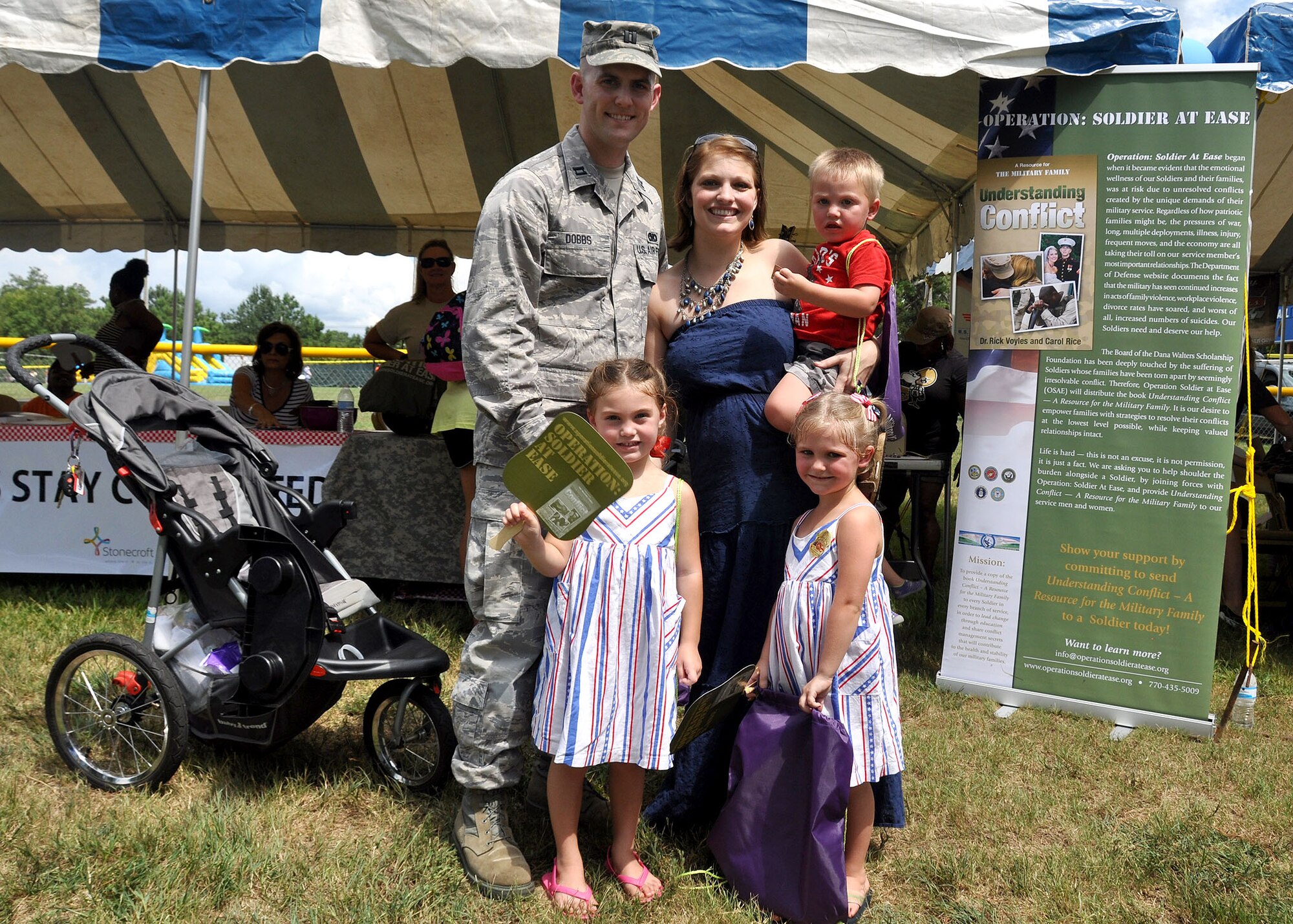 Capt Jeremy Dobbs, 80th Aerial Port Squadron, navigates through Family Day  with his wife Kimberly, two daughters Callie and Eva and his son Elijah Sept. 6, 2014, at Dobbins Air Reserve Base, Ga. The annual event is an opportunity for reserve members and their families to get together for some fun and camaraderie. (U.S. Air Force photo by Staff Sgt. Karla V. Lehman/Released).