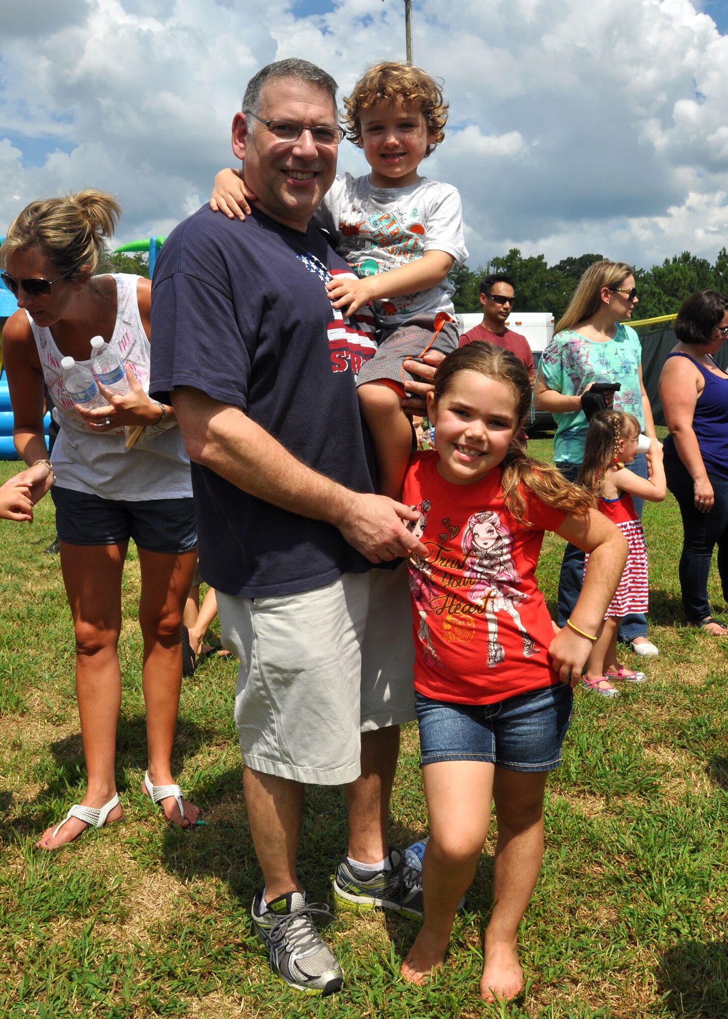 Lt. Col. David Rodberg, 94th Aeromedical Evacuation Squadron flight commander, navigates through Family Day on September 6, 2014 with his son Conor and daughter Dara at Dobbins Air Reserve Base, Ga. Family Day is an annual event celebrating the support family member gives Dobbins Airmen. (U.S. Air Force photo by Staff Sgt. Karla V. Lehman/Released).