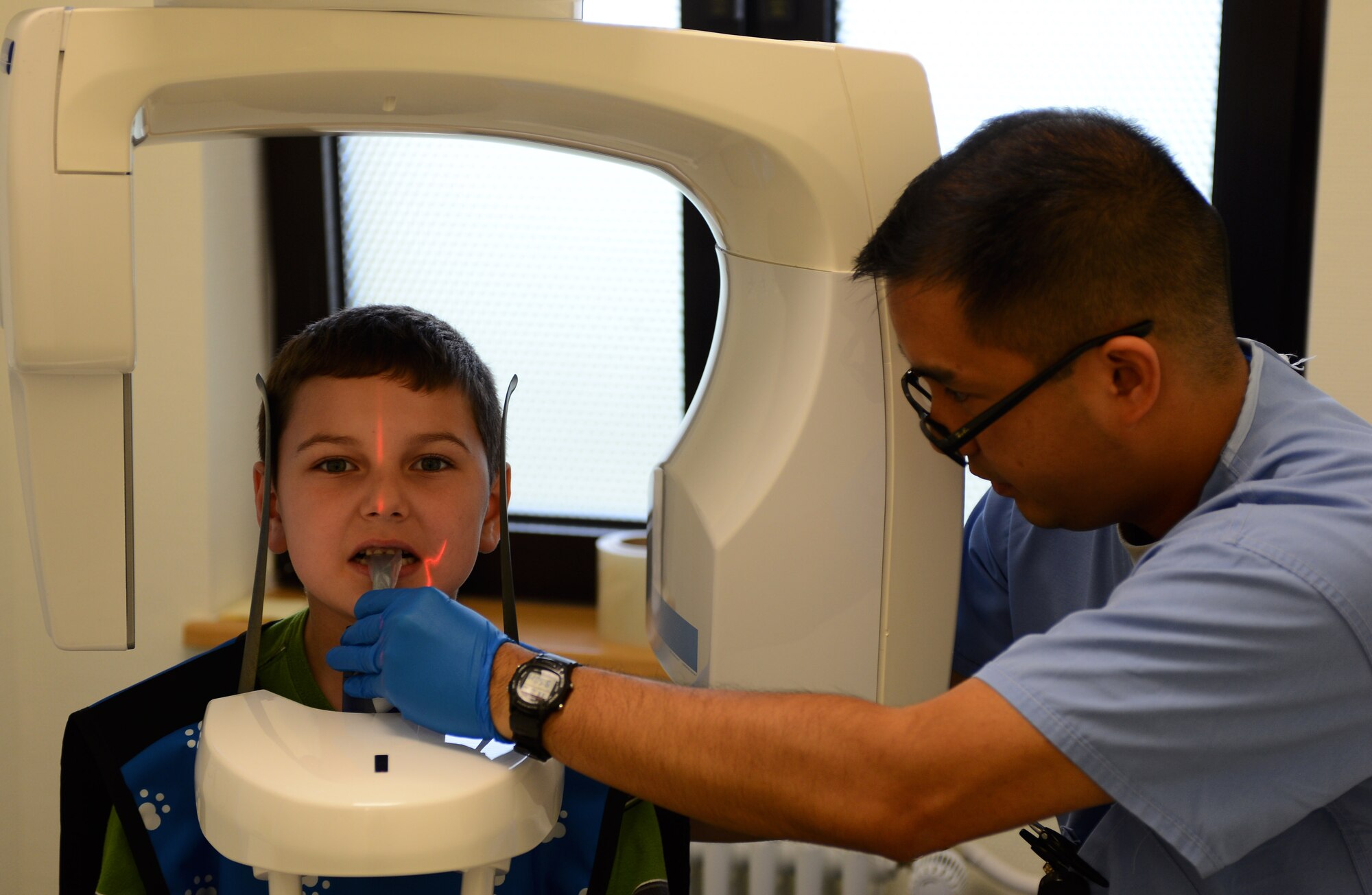 Joel A. McCrae, son of Joseph A. McCrae, gets x-rays of his teeth by U.S. Air Force Staff Sgt. Khaled Johann Ganih, 52nd Dental Squadron radiology technician, during a walk-in children’s dental clinic at Spangdahlem Air Base, Germany, Oct. 10, 2014. The children’s walk-in clinic is held semi-annually and helps provide outreach to children in Spangdahlem and its surrounding geographically separated units. (U.S. Air Force photo by Airman 1st Class Luke J. Kitterman/Released)