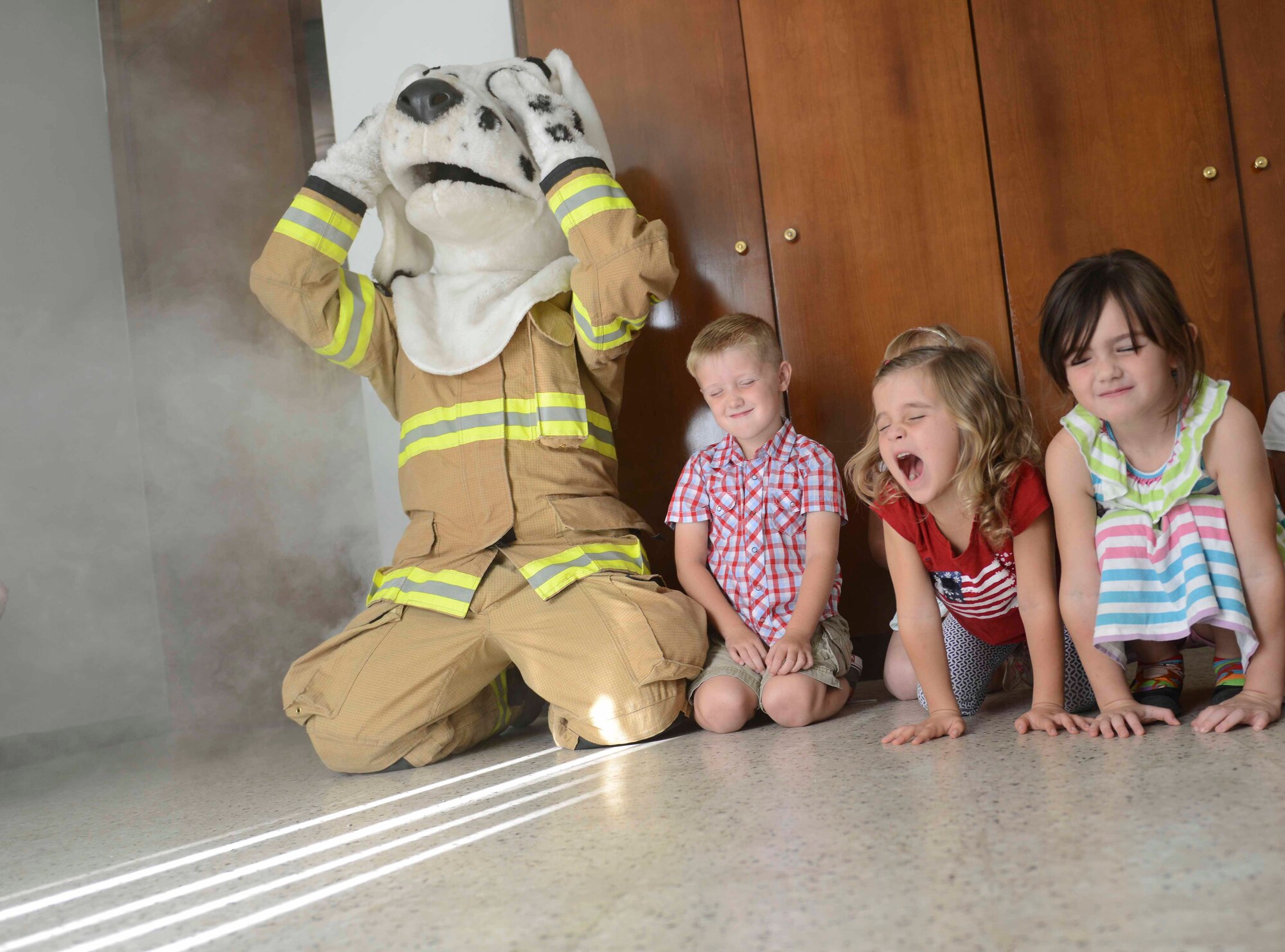 Sparky the Fire Dog and Incirlik Unit School kindergarteners close their eyes and stay close to the floor during a fire drill Oct. 9, 2014, Incirlik Air Base, Turkey. The students learned tips to keep in mind in case of a fire such a staying low to the ground and crawling outside to safety. (U.S. Air Force photo by Staff Sgt Eboni Reams/Released)