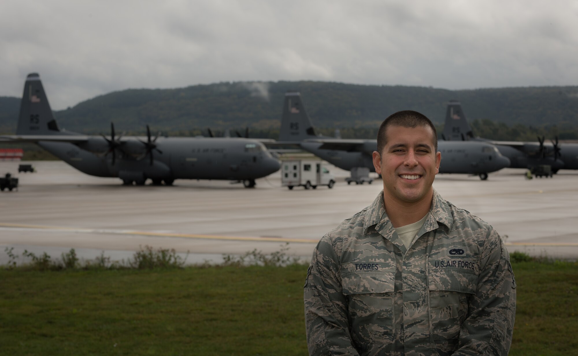 Airman 1st Class Christopher Torres, 86th Aircraft Maintenance Squadron dedicated crew chief, has his photo taken by the flightline after releasing a C-130J Super Hercules with a black letter designation on Ramstein Air Base, Germany, Oct. 7, 2014. A black letter designation indicates that an aircraft is operating under ideal circumstances and has no outstanding mechanical issues or due inspections. (U.S. Air Force photo/Airman 1st Class Jordan Castelan)