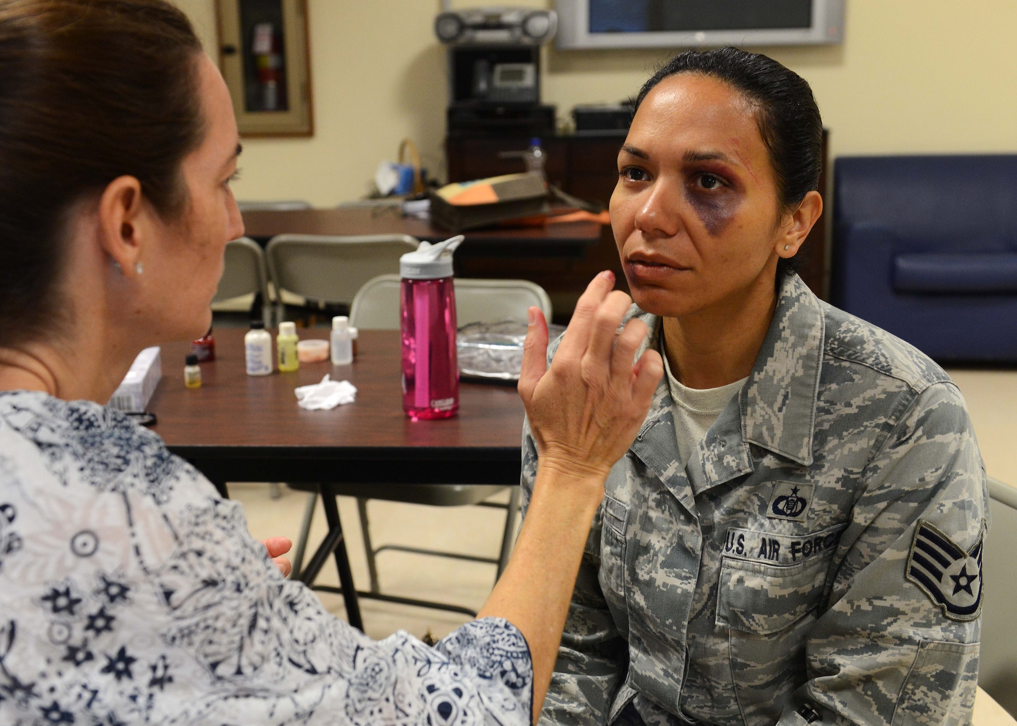 Fake bruises are moulaged on Staff Sgt. Elizabeth Velez, 555th Fighter Squadron, as part of the Black Eye Campaign, Oct. 3, 2014, at Aviano Air Base, Italy. To help promote Domestic Violence Awareness Month, officers, enlisted, civilian employees and spouses roamed the base with fake bruises to see if fellow Airmen and co-workers would step up and ask them if they are okay. (U.S. Air Force photo/Airman 1st Class Deana Heitzman)