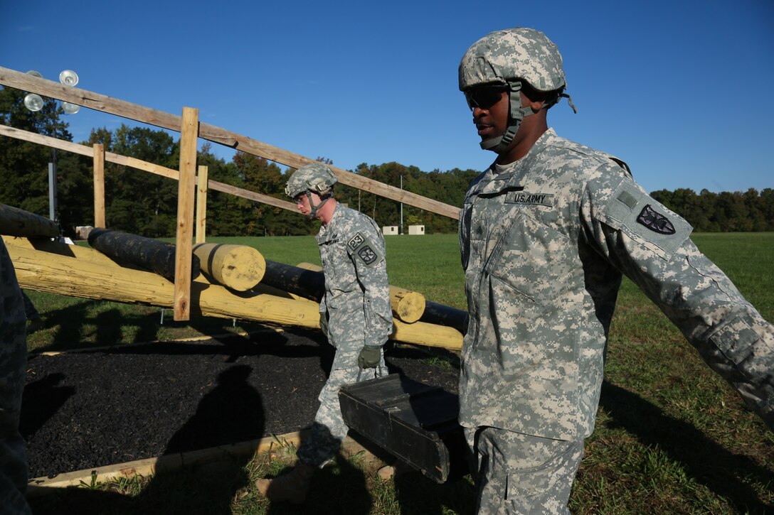 Army Sgt. 1st Class David Smith, left, navigates an obstacle course during the Best Warrior Competition on Fort Lee, Va., Oct. 9, 2014. Smith is assigned to the U.S. Army Training and Doctrine Command.