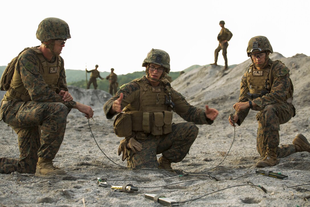 U.s. Marine Corps Cpl. Cory Stryker, Middle, Explains How To Arm C4 