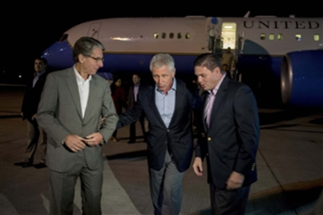 U.S. Defense Secretary Chuck Hagel, center, speaks with U.S. Ambassador to Colombia Kevin Whitaker, left, and Colombian Defense Minister Juan Carlos Pinzon Bueno as he arrives at El Dorado International Airport in Bogota, Colombia, Oct. 9, 2014. Hagel will attend the 11th Conference of the Defense Ministers of the Americas during his South American trip.