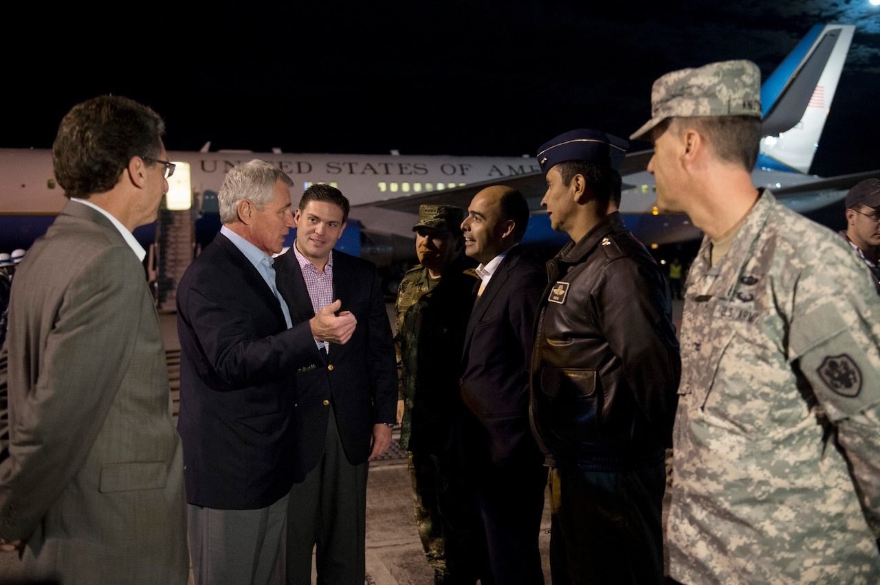 Defense Secretary Chuck Hagel, left, speaks with U.S. and Colombian military officials as he arrives at El Dorado International Airport in Bogota, Colombia, Oct. 9, 2014. DoD photo by Air Force Master Sgt. Adrian Cadiz