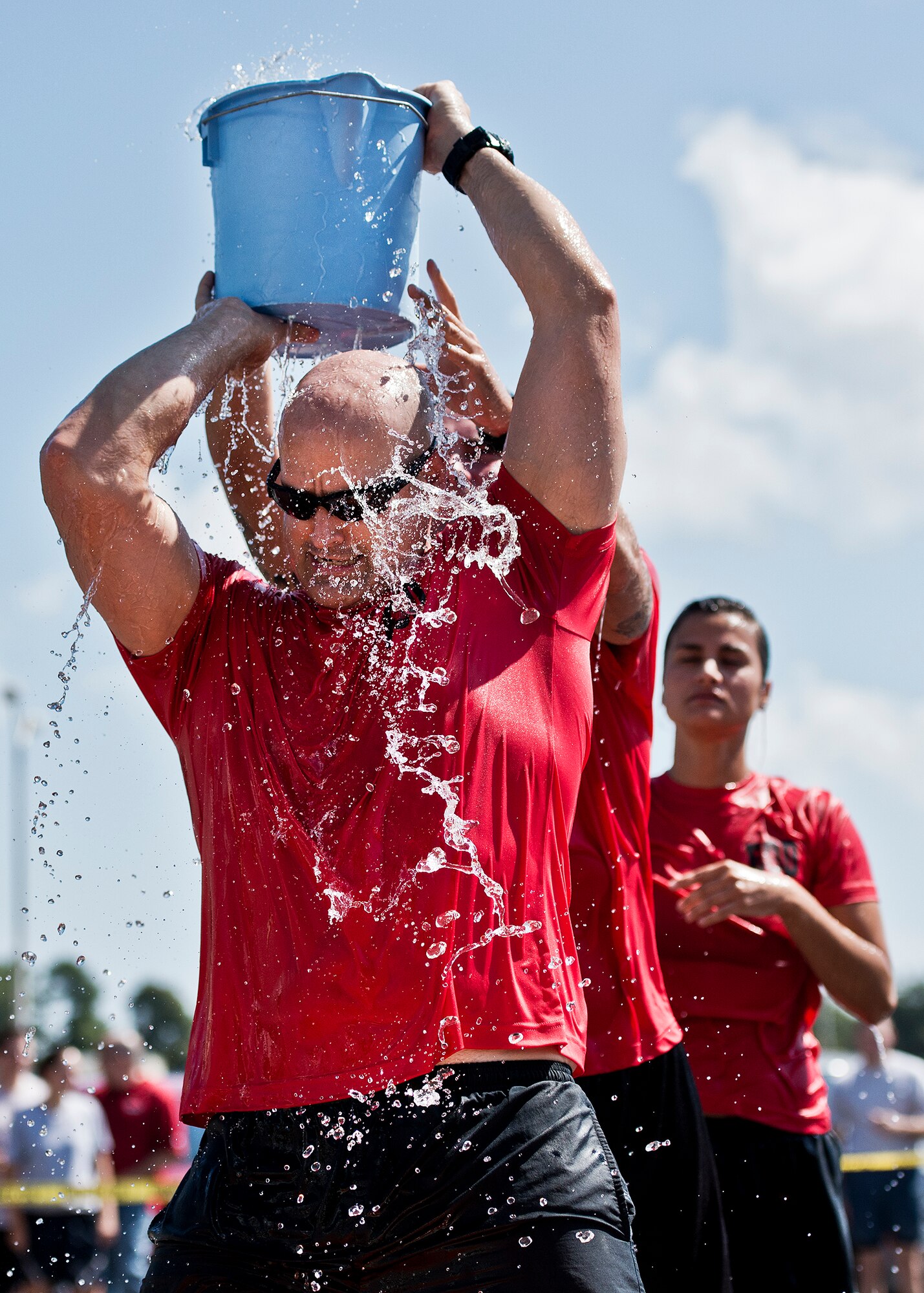The Explosive Ordnance Disposal team transfers a holey bucket of water from a pool to a large barrel during this year’s Fire Muster Challenge Oct. 10 at Eglin Air Force Base, Fla.  Teams competed in the challenge that included shooting and rolling up the fire hose, victim-carry and water relay. The EOD team won the challenge with the best overall time.  (U.S. Air Force photo/Samuel King Jr.)