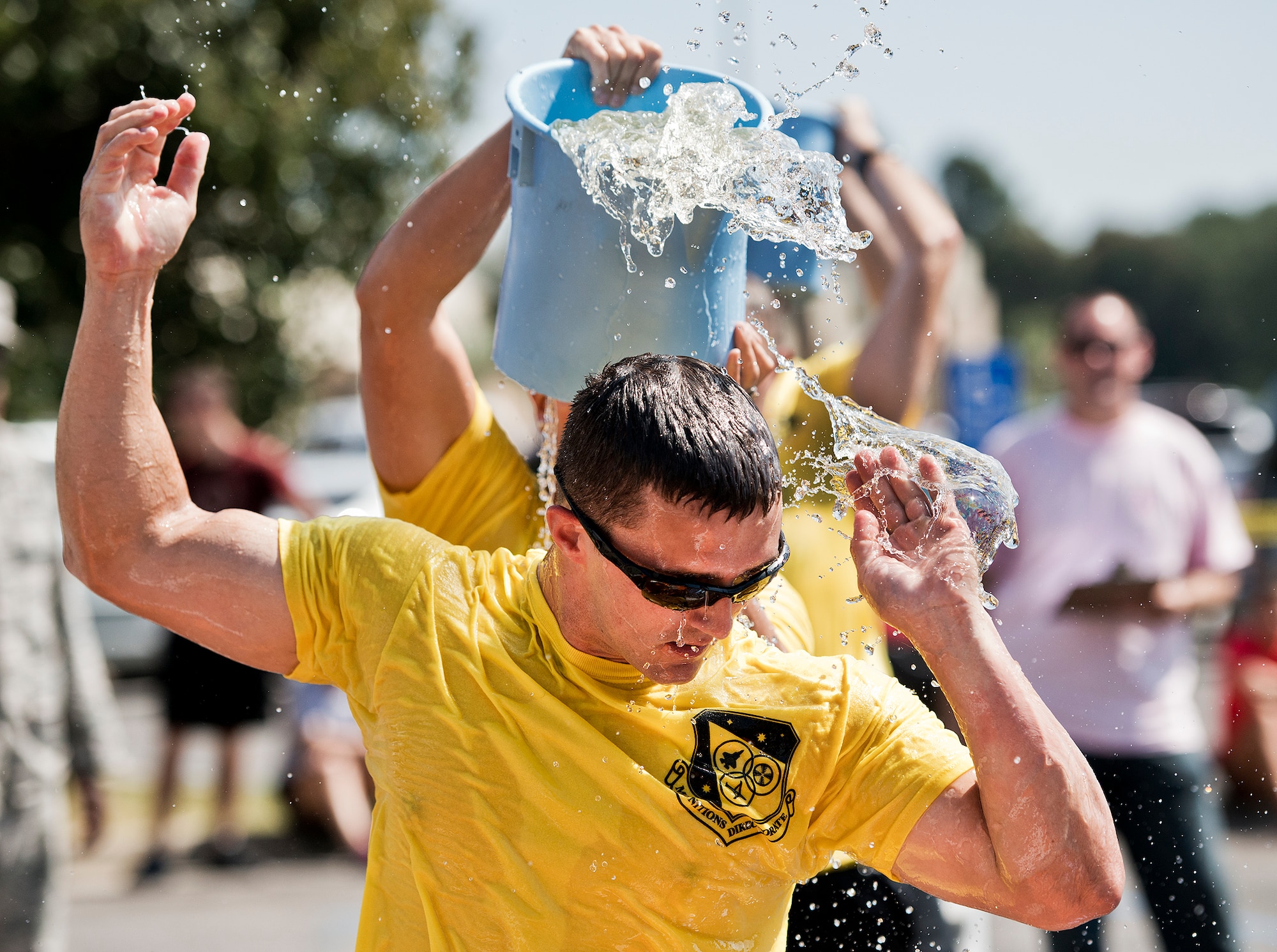 The Air Force Research Lab team transfers a holey bucket of water from a pool to a large barrel during this year’s Fire Muster Challenge Oct. 10 at Eglin Air Force Base, Fla.  Teams competed in the challenge that included shooting and rolling up the fire hose, victim-carry and water relay. (U.S. Air Force photo/Samuel King Jr.)