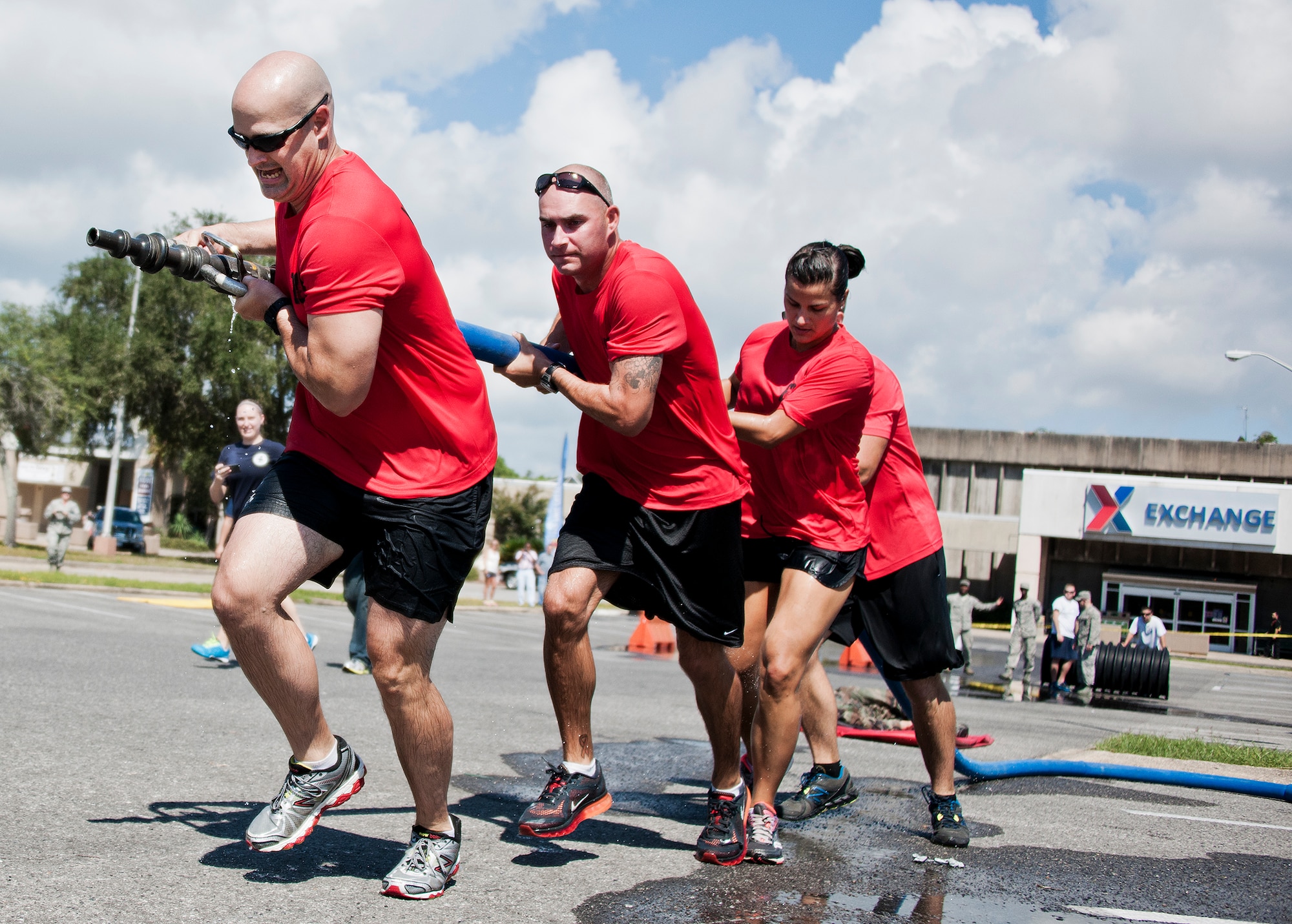 The Explosive Ordnance Disposal team pulls a full fire hose toward their target during this year’s Fire Muster Challenge Oct. 10 at Eglin Air Force Base, Fla.  Teams competed in the challenge that included shooting and rolling up the fire hose, victim-carry and water relay.   The EOD team won the challenge with the best overall time.  (U.S. Air Force photo/Samuel King Jr.)