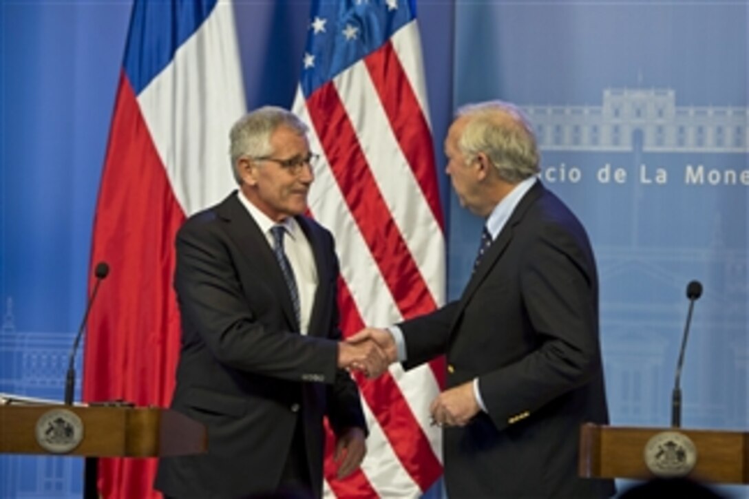 U.S. Defense Secretary Chuck Hagel shakes hands with Chilean Defense Minister Jorge Burgos at the end of a joint press conference in Santiago, Chile, Oct. 11, 2014. Hagel earlier visited Colombia and will travel to Peru during a six-day trip to South America.