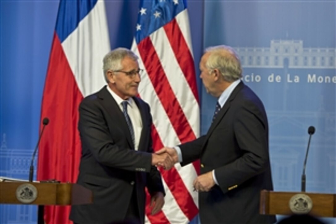U.S. Defense Secretary Chuck Hagel shakes hands with Chilean Defense Minister Jorge Burgos at the end of a joint press conference in Santiago, Chile, Oct. 11, 2014. Hagel earlier visited Colombia and will travel to Peru during a six-day trip to South America.
