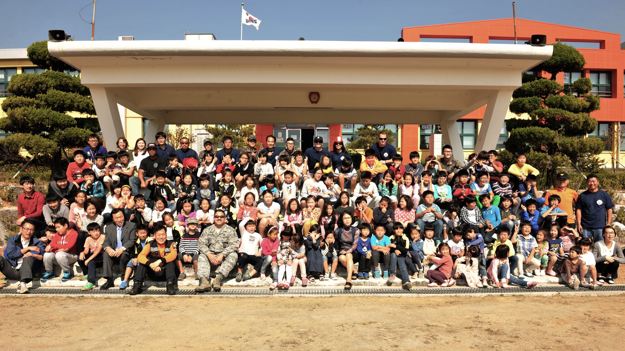 Okbong Elementary School children pose for a photo with fire department members from the 8th Civil Engineer Squadron, Republic of Korea air force 38 Fighter Group and local Gunsan City following a fire safety demonstration Oct. 7, 2014. Fire prevention week is the longest running public health and safety observance on record. (U.S. Air Force photo by Senior Airman Katrina Heikkinen/released) 