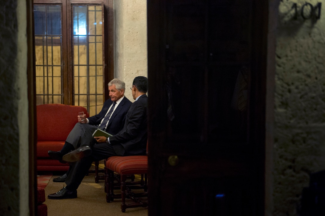 U.S. Defense Secretary Chuck Hagel speaks with Rexon Ryu, his chief of staff, in Arequipa, Peru, Oct. 12, 2014, before the start of the 11th Conference of the Defense Ministers of the Americas. 