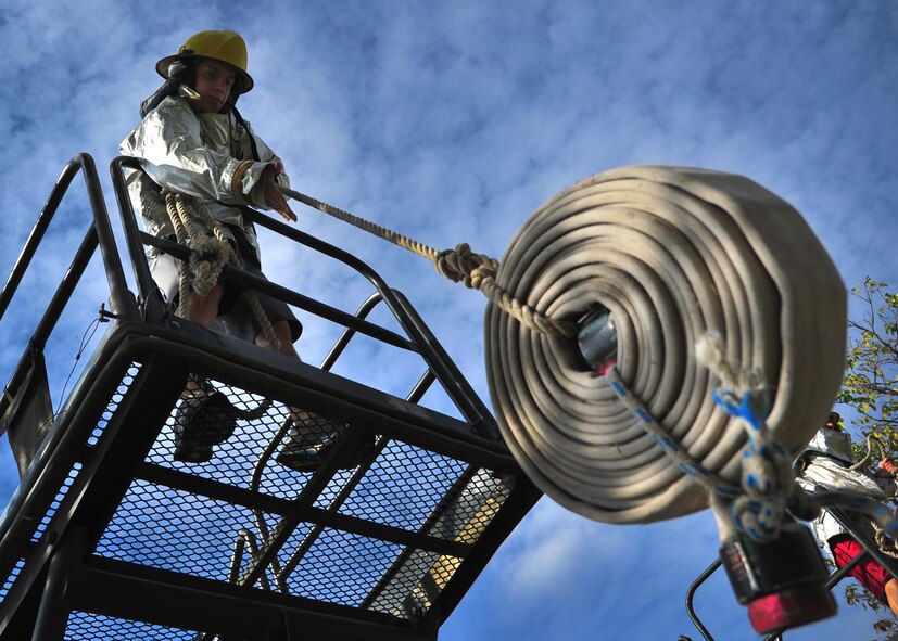 A U.S. Air Force airman hoists a rolled-up fire hose up a flight of stairs during the 15th Annual Squadron Fire Muster Oct. 9, 2014 at Cannon Air Force Base, N.M. Eight teams from various squadrons across the 27th Special Operations Wing gathered to compete in this year’s competition. (U.S. Air Force photo/Staff Sgt. Alexxis Pons Abascal) 