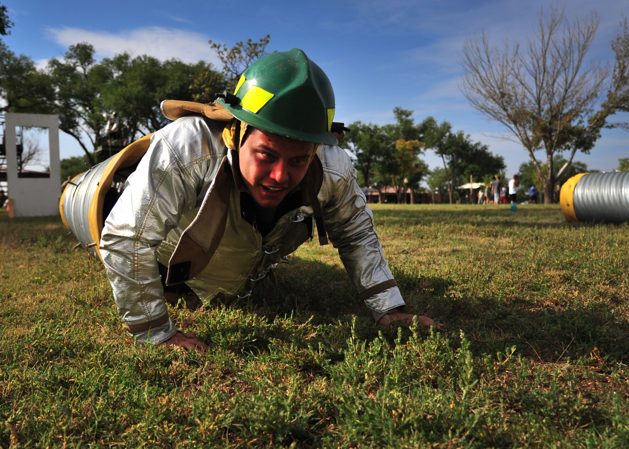 A U.S. Air Force airman struggles through an obstacle during the 15th Annual Squadron Fire Muster Oct. 9, 2014 at Cannon Air Force Base, N.M. Despite a wide range of Air Force Specialty Codes, airmen were able to gather and experience first-hand firefighting techniques, while gaining knowledge on how to promote fire safety awareness throughout the installation and respective work centers. (U.S. Air Force photo/Staff Sgt. Alexxis Pons Abascal)