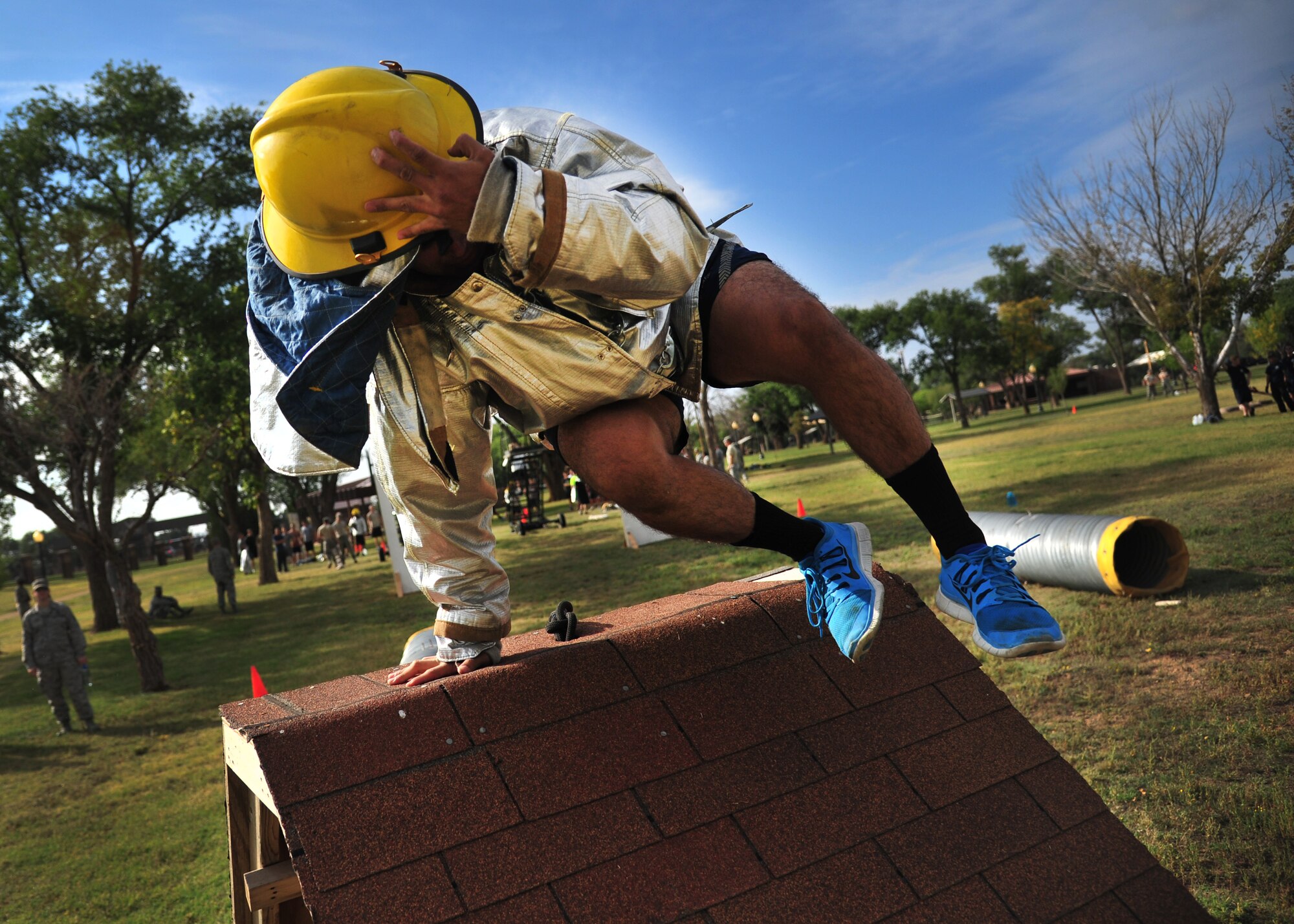 A U.S. Air Force airman leaps over a barricade obstacle during the 15th Annual Squadron Fire Muster Oct. 9, 2014 at Cannon Air Force Base, N.M. This year’s Fire Prevention Week theme at Cannon was “Working Smoke Alarms Save Lives, Test Yours Every Month.” (U.S. Air Force photo/Staff Sgt. Alexxis Pons Abascal)
