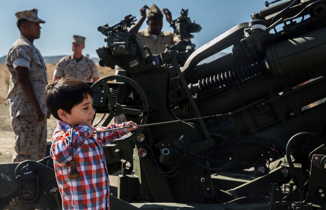 A U.S. Marine’s son pulls the lanyard on an M777A2 Lightweight Howitzer after the composite ceremony for the 15th Marine Expeditionary Unit aboard Camp Pendleton, Calif., Oct. 10, 2014. (U.S. Marine Corps photo by Sgt. Emmanuel Ramos/Released)