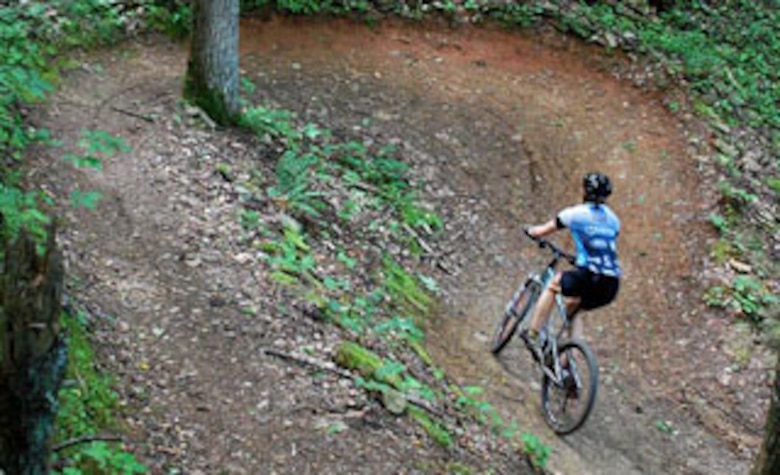A mountain bicyclist maneuvers a hairpin turn on the Berry Mountain Loop trail at the Wilmington District's W. Kerr Scott Dam and Reservoir in Wilkesboro, North Carolina.  
