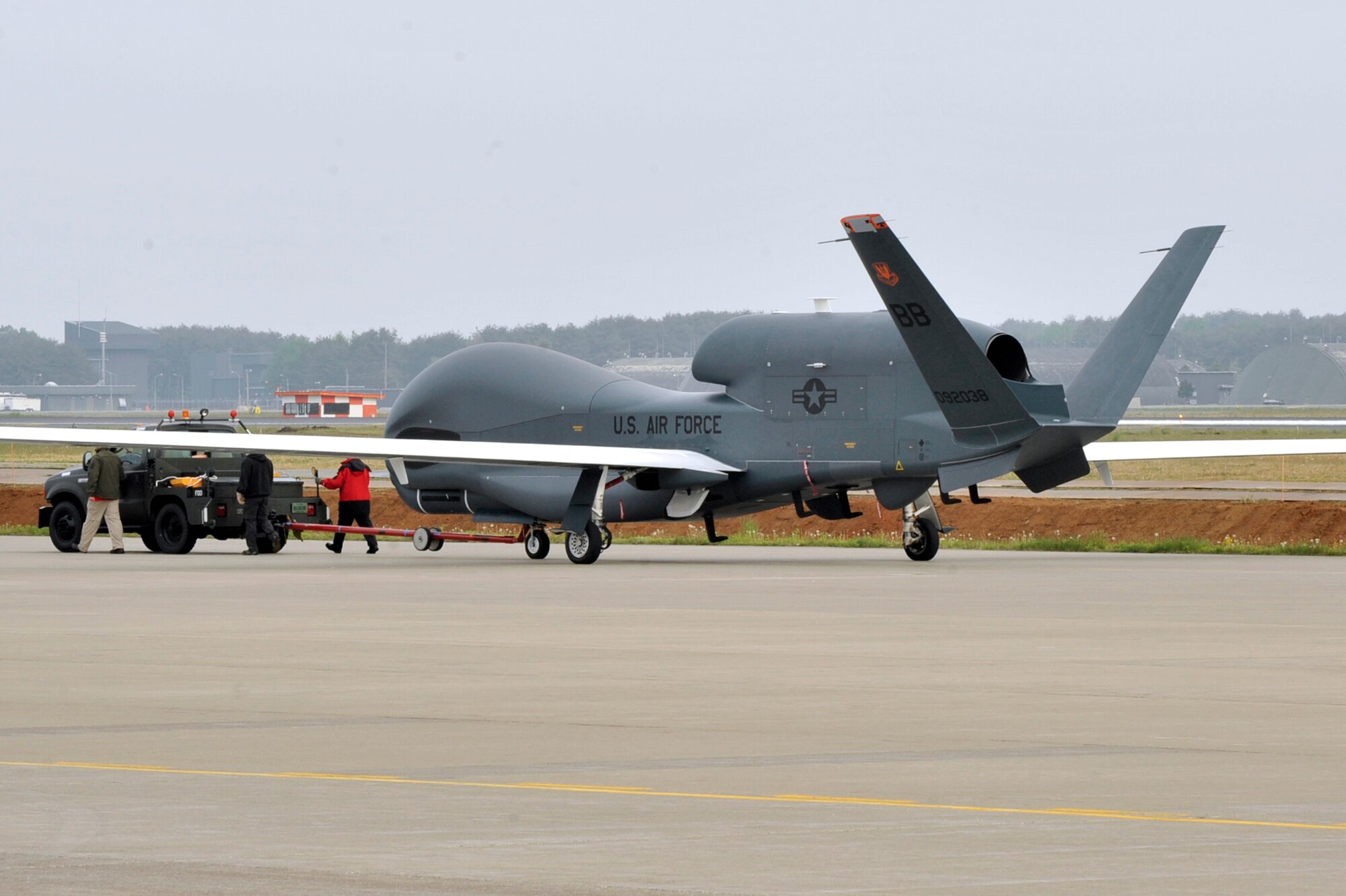 An RQ-4 Global Hawk from Andersen Air Force Base, Guam, is towed down the runway at Misawa Air Base, Japan, May 24, 2014. The Global Hawk was on a temporary rotation to Japan, in part by the adverse impact of inclement summer weather in Guam. Given the number of sorties lost due to typhoons and thunderstorms, the need to look for alternate summer basing options arose.  Misawa AB was chosen as an ideal location for the Global Hawk, its equipment and personnel. (U.S. Air Force Photo/ Staff Sgt. Tong Duong)