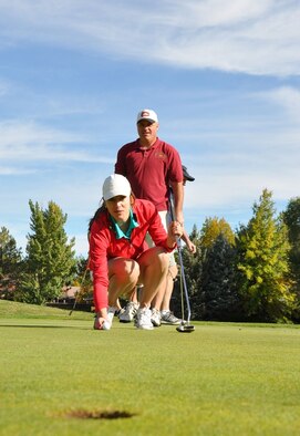 Allie Scurry places her ball and measures her putt as Senior Master Sgt. Scott Jasper looks on during the Nevada National Guard Association Golf Tournament in Reno on Monday. Scurry played for the winning Air Guard team in the best-ball scramble that the High Rollers won by one stroke at Lakeridge Golf Club.

Photo by Maj. Dennis Fournier
