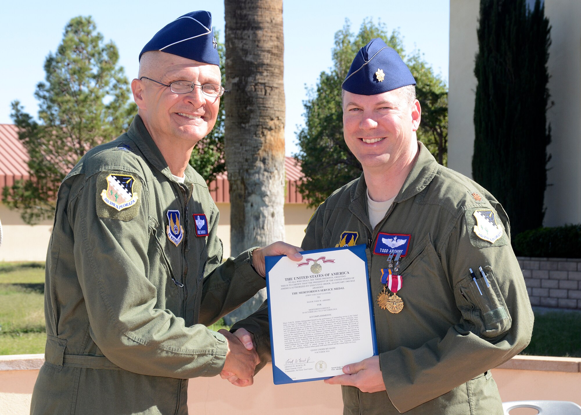 Maj. Gen. Arnold Bunch Jr. (left), Air Force Test Center commander, and Maj. Todd Abshire, AFTC Safety Office, pose for a photo with Abshire's Air Medal certificate Oct. 14. Abshire has spent the last two years assigned to the center with a year-long deployment to Afghanistan. (U.S. Air Force photo by Kenji Thuloweit)