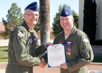 Maj. Gen. Arnold Bunch Jr. (left), Air Force Test Center commander, and Maj. Todd Abshire, AFTC Safety Office, pose for a photo with Abshire's Air Medal certificate Oct. 14. Abshire has spent the last two years assigned to the center with a year-long deployment to Afghanistan. (U.S. Air Force photo by Kenji Thuloweit)