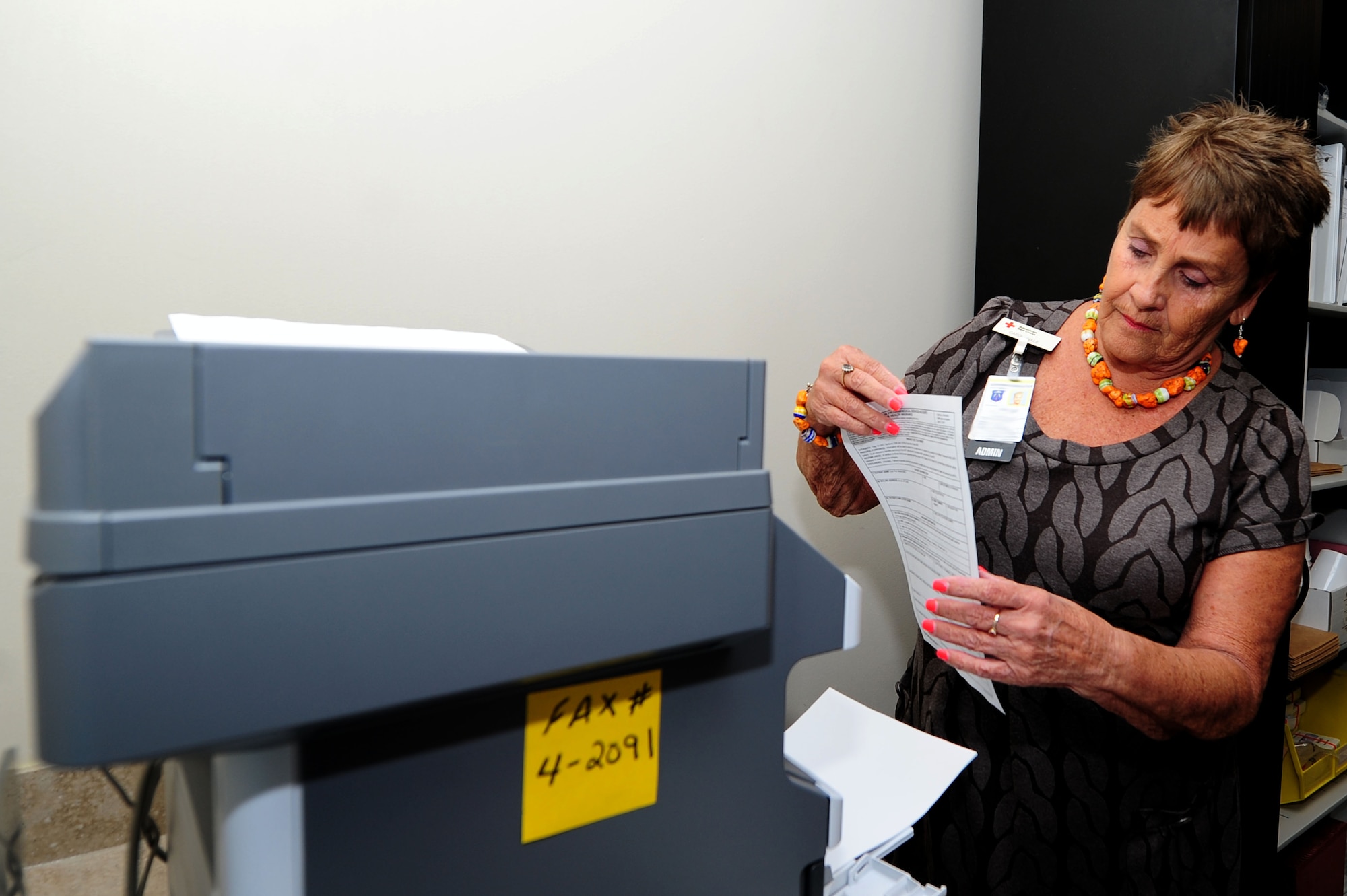 Carol Hale, 633rd Medical Group Red Cross laboratory volunteer, prepares to send a fax at Langley Air Force Base, Va., Oct. 8, 2014. One of Hale’s daily duties includes ensuring civilian scripts are up to date when Joint Base Langley-Eustis members are given medical attention off base. (U.S. Air Force photo by Airman 1st Class Areca T. Wilson/Released) 