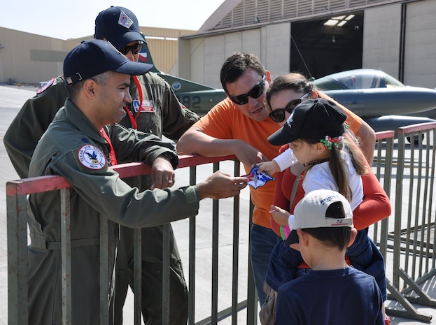 Lt. Col. Raul Rosales, detachment commander from the Texas Air National Guard's 149th Fighter Wing at Joint Base San Antonio, Texas, hands a unit patch to a Chilean child during an Open Day at Exercise Salitre 2014 Oct. 11 at Cerro Moreno Air Base, Chile. More than 80 Airmen from the Texas and Ohio Air National Guard are taking part of the Chile-led exercise which also features air forces from Brazil, Argentina and Uruguay. (U.S. Air Force photo by Capt. Bryan Bouchard/Released)