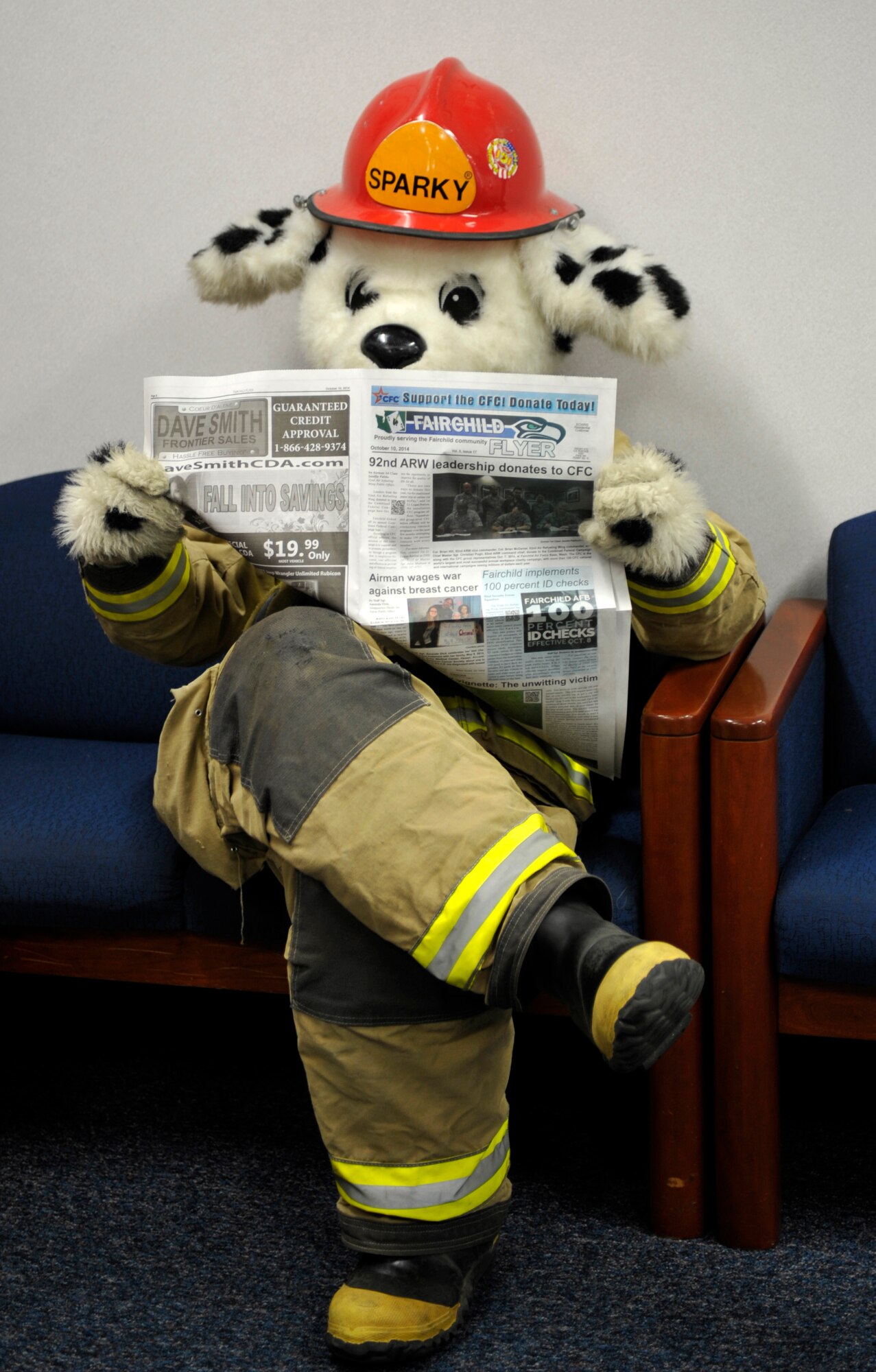Sparky the Fire Dog reads the Fairchild Flyer while waiting to meet with children at Michael Anderson Elementary School, Oct. 10, 2014, at Fairchild Air Force Base, Washington. During Fire Prevention Week 2014, Sparky made many appearances around base to help bring awareness to fire safety. (U. S. Air Force photo by Airman 1st Class Taylor Bourgeous) 