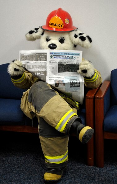 Sparky the Fire Dog reads the Fairchild Flyer while waiting to meet with children at Michael Anderson Elementary School, Oct. 10, 2014, at Fairchild Air Force Base, Washington. During Fire Prevention Week 2014, Sparky made many appearances around base to help bring awareness to fire safety. (U. S. Air Force photo/Airman 1st Class Taylor Bourgeous) 

