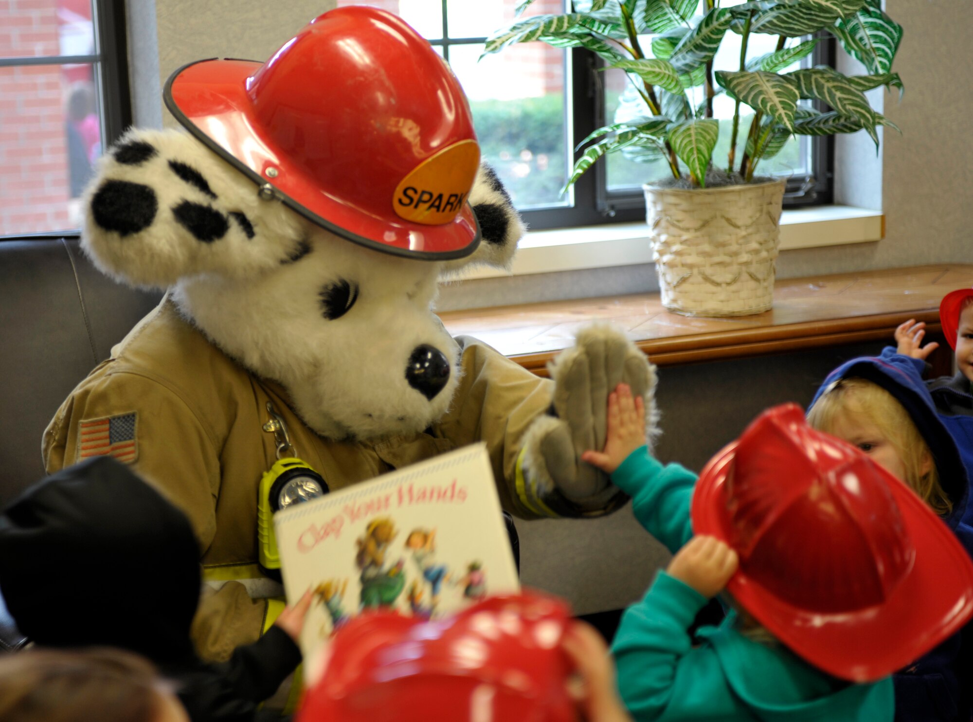 Sparky the Fire Dog visits with the children at the base Child Development Center Oct. 8, 2014, at Fairchild Air Force Base, Washington. Sparky made many appearances around base to help spread awareness about fire safety during Fire Prevention Week 2014. (U. S. Air Force photo by Airman 1st Class Taylor Bourgeous)