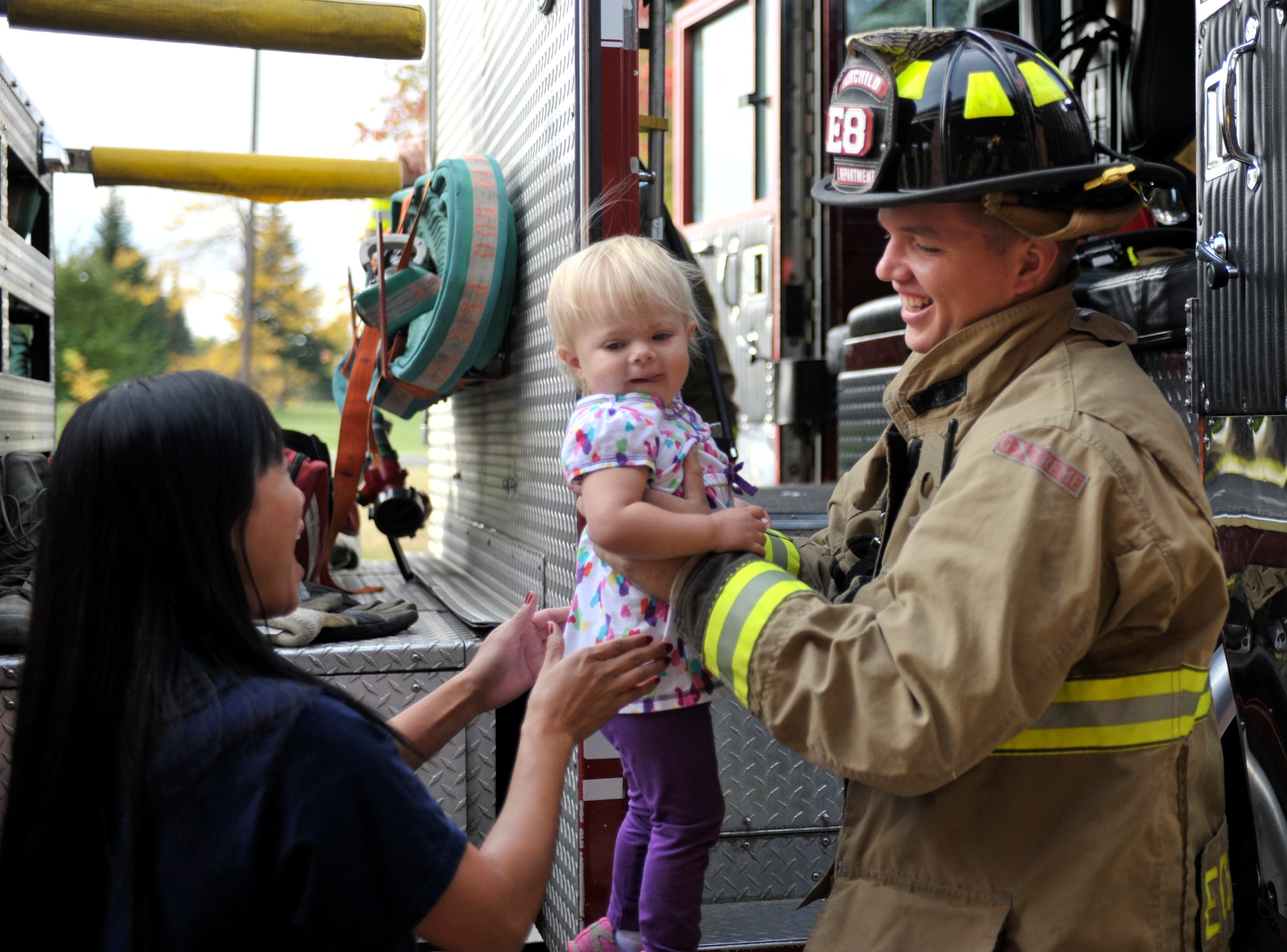 Senior Airman Brandon Eichenlaub, a 92nd Civil Engineer Squadron firefighter, helps a little girl off of the fire truck at the Child Development Center during a visit from the base firefighters Oct. 8, 2014, at Fairchild Air Force Base, Washington. For Fire Prevention Week 2014, the base fire department visited the CDC and let the children explore the fire trucks and meet with Sparky the Fire Dog. (U. S. Air Force photo by Airman 1st Class Taylor Bourgeous)