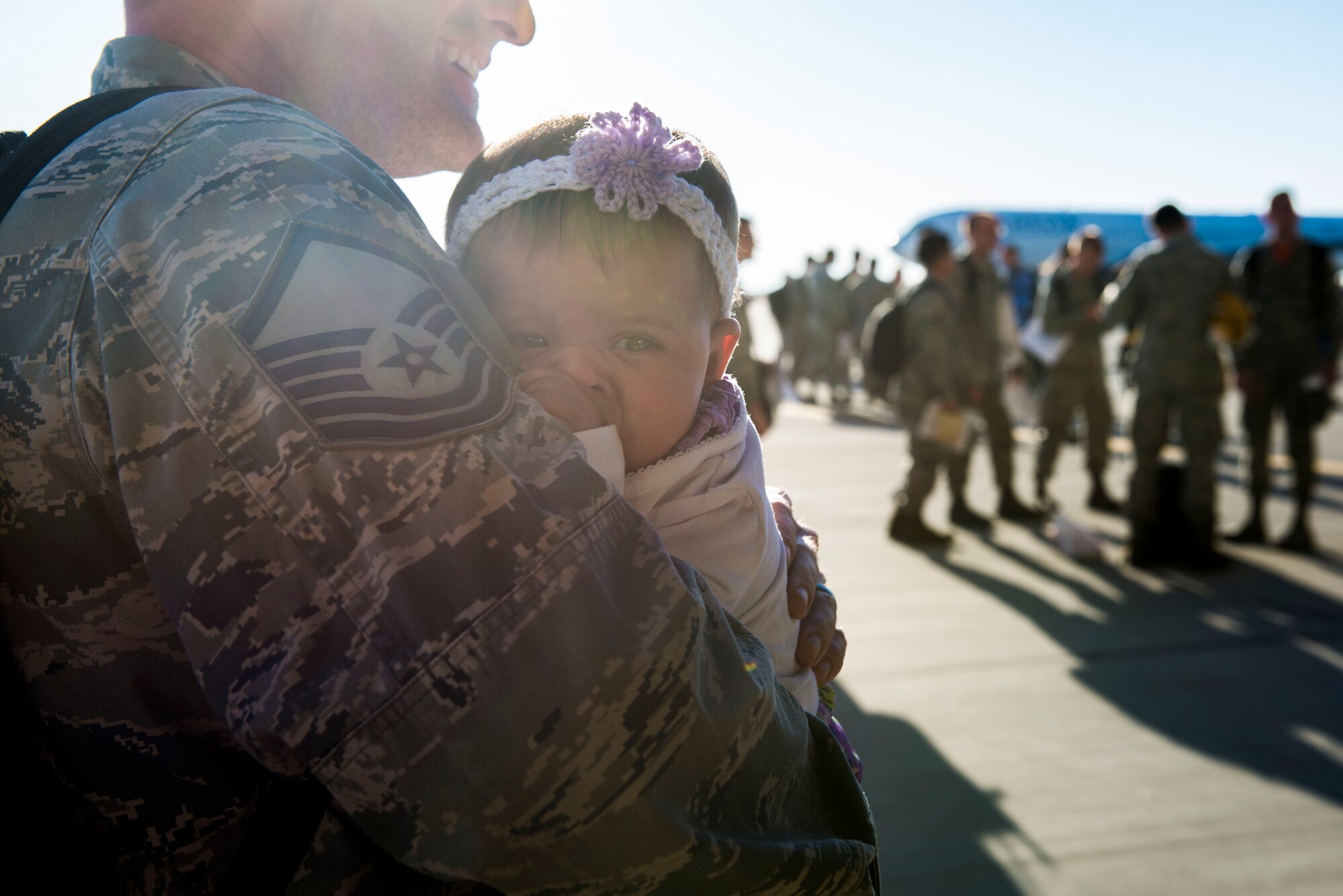 A Master Sergeant holds his daughter for the first time in six months after returning to Mountain Home Air Force Base, Idaho, Oct. 10, 2014, from a deployment. Family and friends of the 391st Fighter Squadron gathered and waited in anticipation for the homecoming of their loved ones. (U.S. Air Force photo by Airman 1st Class Jessica H. Smith/ RELEASED)
