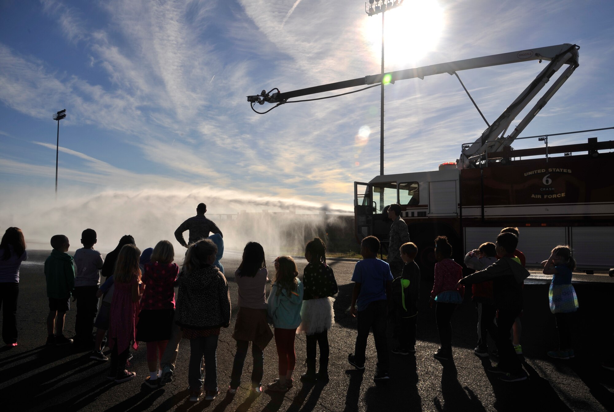 Students from Michael Anderson Elementary School watch as a 92nd Civil Engineer Squadron firefighter demonstrates how different parts of a crash truck work during a tour of the fire department at Fairchild Air Force Base, Washington, Oct. 6, 2014. The tour, along with several other events around base, was held to bring awareness to fire safety and prevention during Fire Prevention Week 2014. (U.S. Air Force photo by Senior Airman Mary O'Dell)
