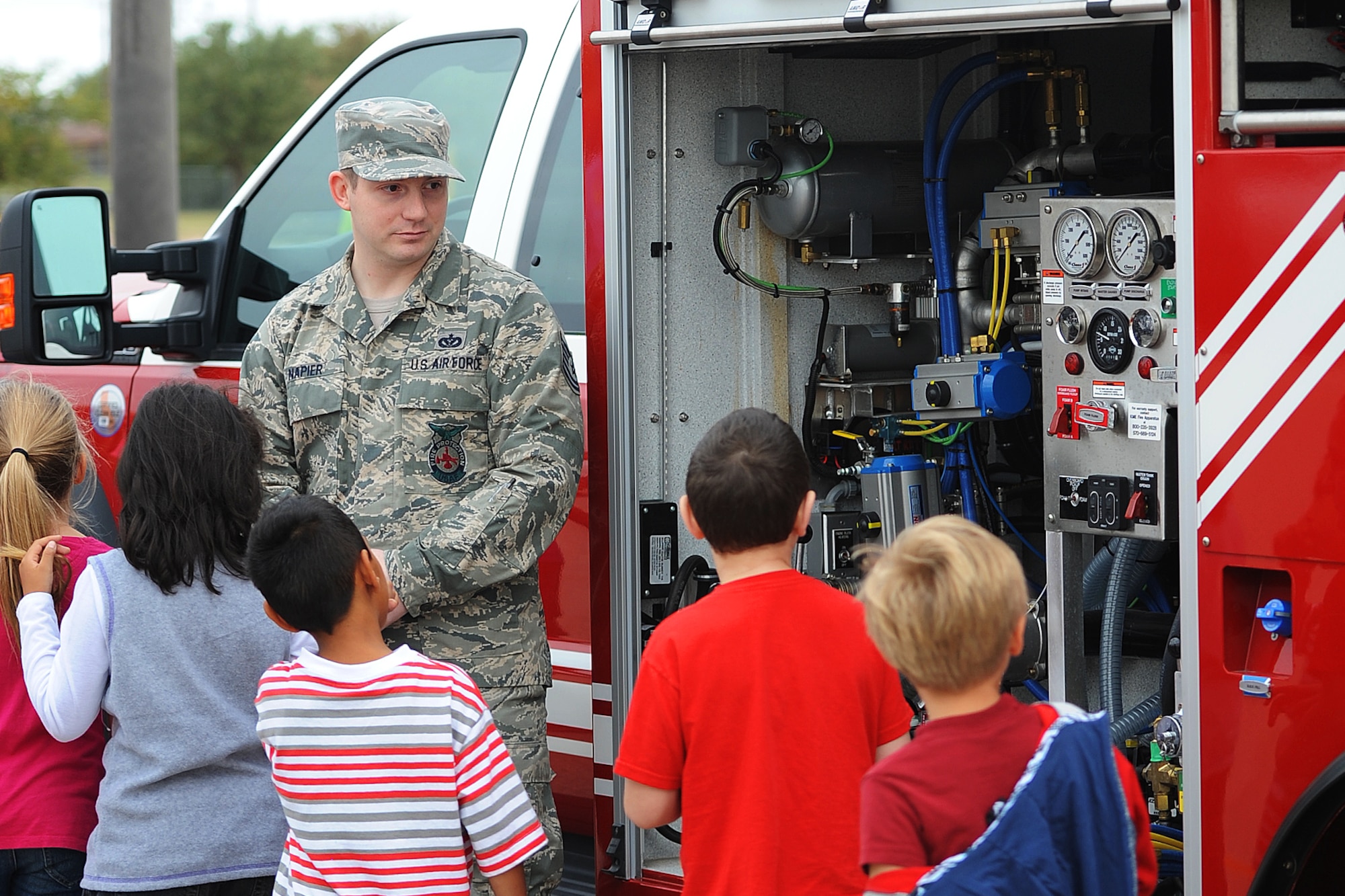 SAN ANGELO, Texas – Tech. Sgt. Joshua D. Napier, 312th Training Squadron instructor, shows Lamar Elementary School students the inside of a rapid intervention vehicle at Lamar Elementary School Oct. 6. The 312th TRS visited 26 local elementary schools throughout the week to teach children fire safety as part of Fire Prevention Week. (U.S. Air Force photo/ Airman 1st Class Devin Boyer)