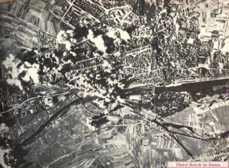 Bombs from the first wave of B-17s falling on Schweinfurt on "Black Thursday."  Bombs are hitting the Kugelfischer and VKF-Werk I factories and the railroad marshalling yards just west of the downtown area, but are also falling on residential areas north and west of downtown, and some bombs are falling very wide of the mark south of the Main River and downriver to the southwest.  (U.S. National Archives, RG 342-FH-3A22431)