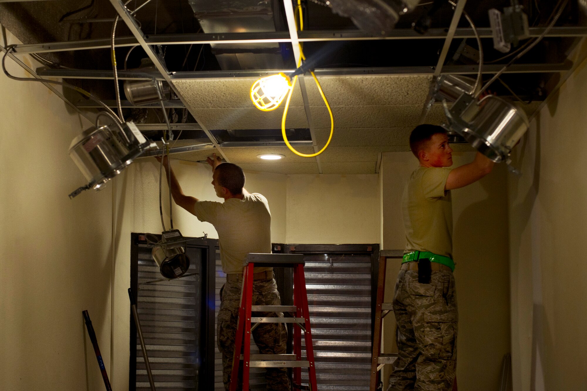 Airmen from the 5th Civil Engineering Squadron replace the ceiling tile of the Law Enforcement Desk on Minot Air Force Base, N.D., Oct. 7, 2014. The LE Desk has been relocated to the fire department dispatch office until the renovations are finished. (U.S. Air Force photo/Senior Airman Brittany Y. Bateman)
