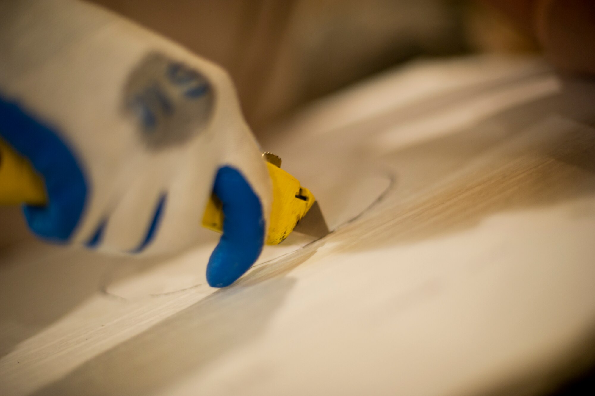 An Airman from the 5th Civil Engineering Squadron cuts a hole into a ceiling tile during reconstruction of the Law Enforcement Desk office on Minot Air Force Base, N.D., Oct. 7, 2014. The LE Desk is the primary control center for all law enforcement-based responses here, and it is also the subordinate or backup control center for all security-based responses on base.  (U.S. Air Force photo/Senior Airman Brittany Y. Bateman)